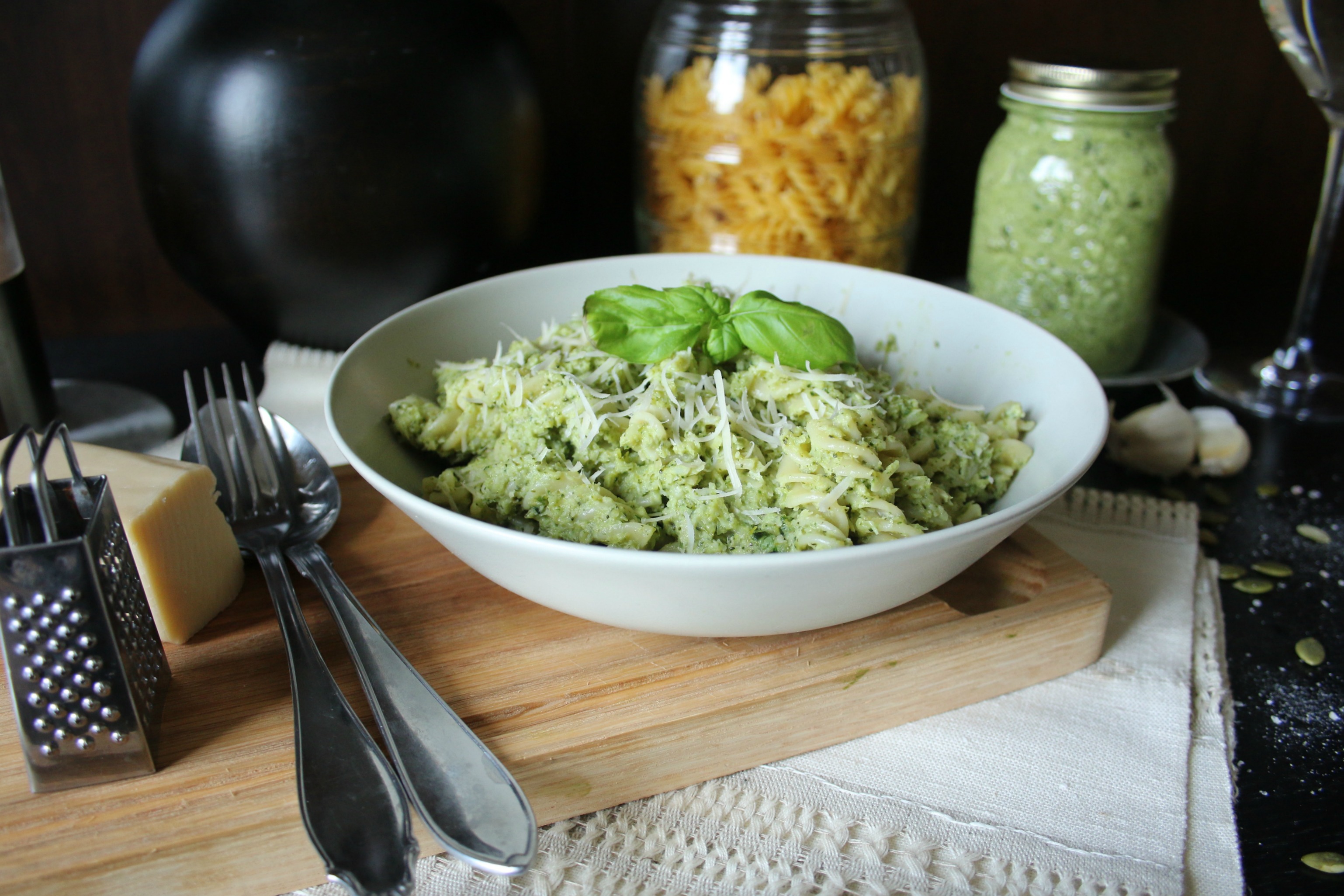 Broccolipesto med pasta i en vit tallrik på en skärbräda