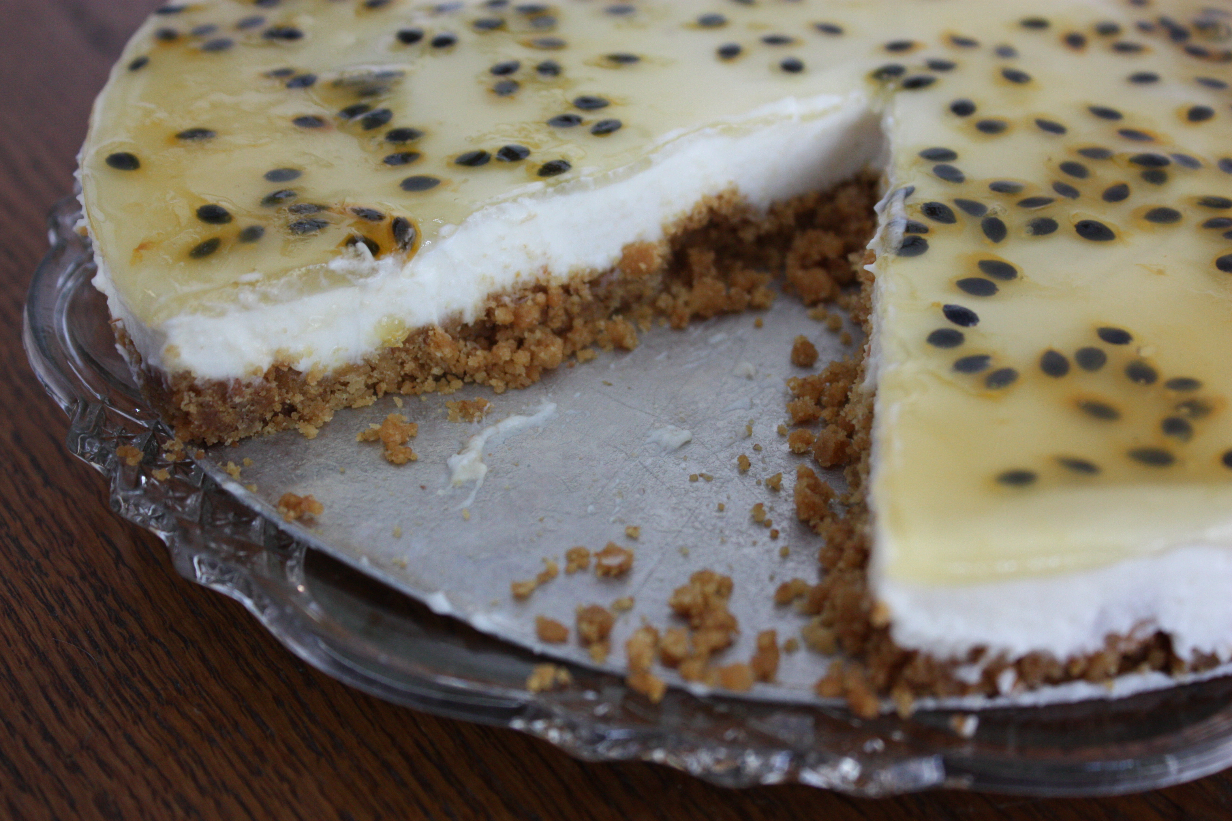 Citroncheesecake med passionsfrukt på ett tårtfat.