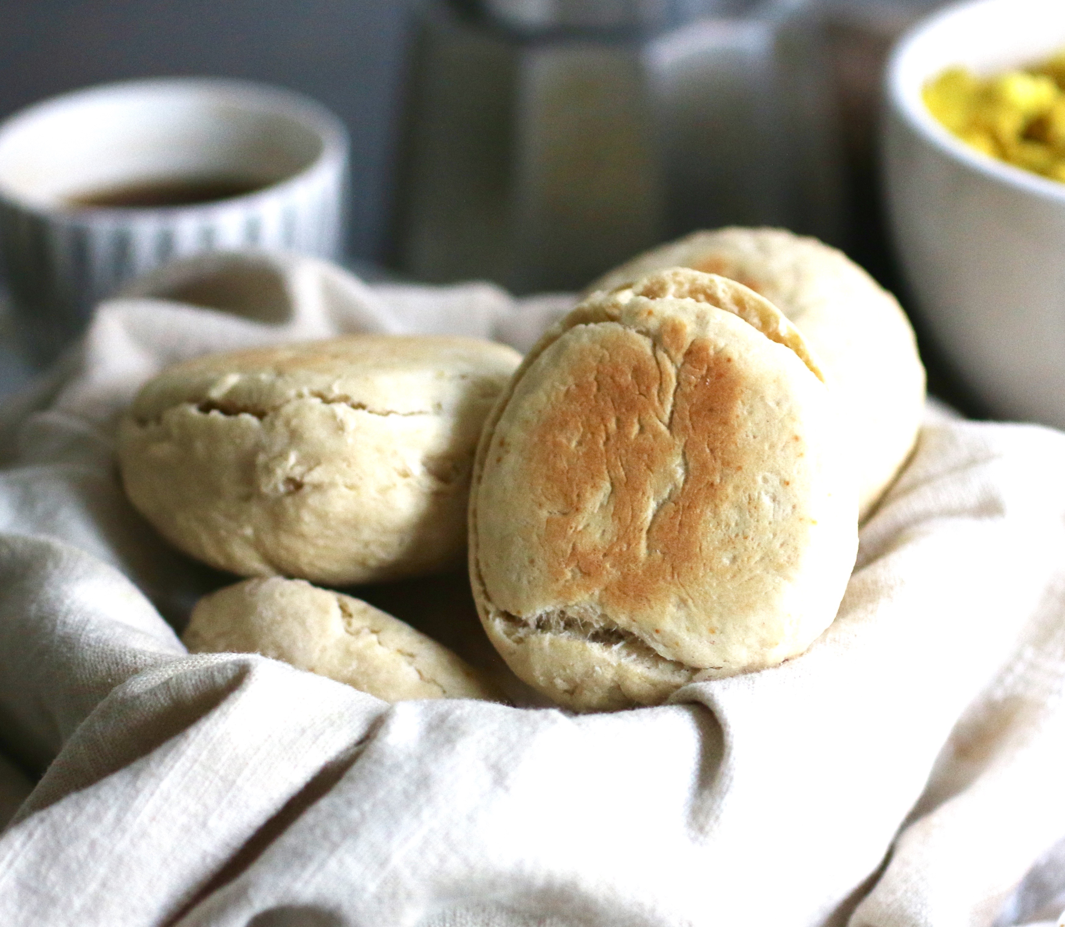 Scones i en korg, i bakgrunden syns en kopp kaffe.