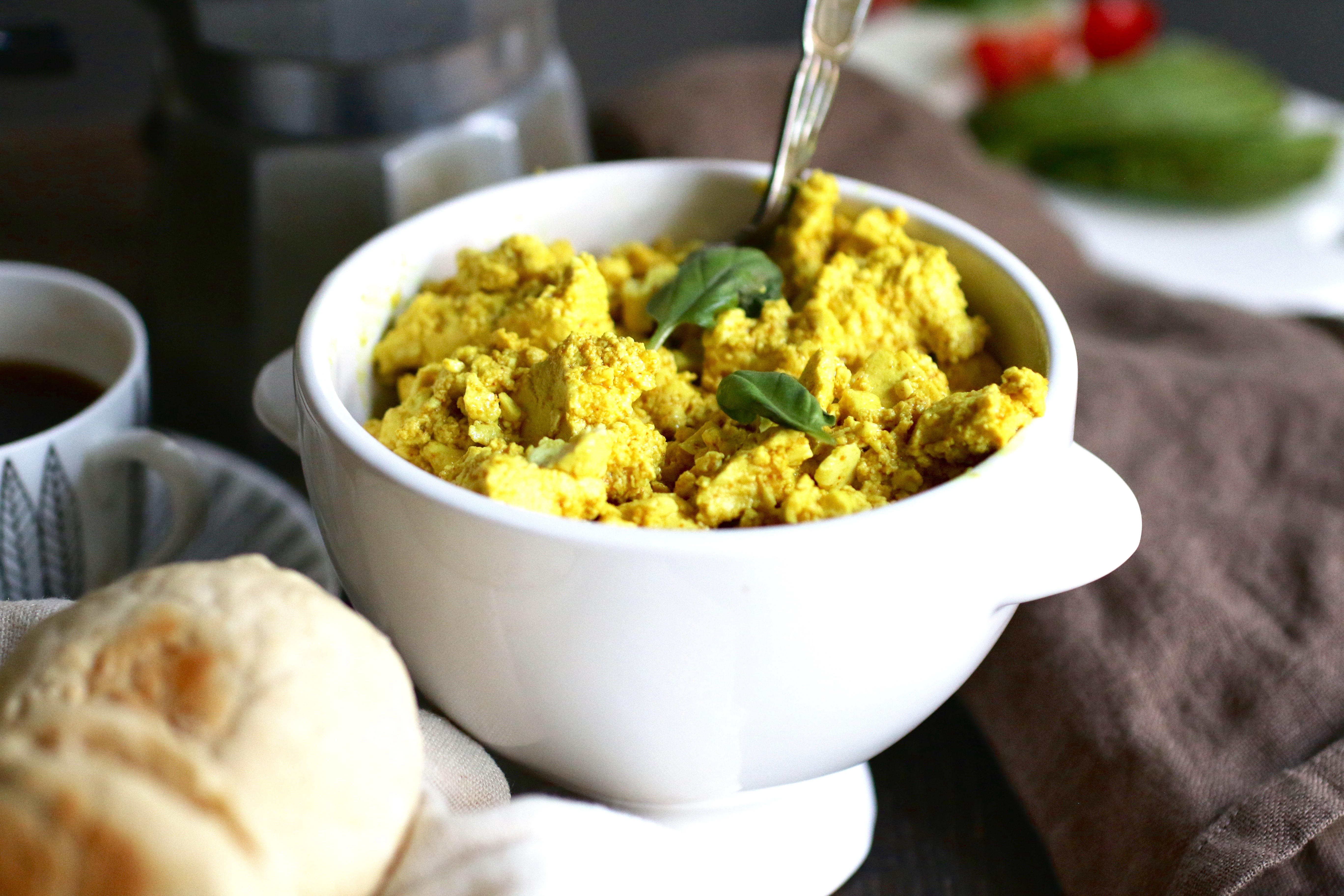Scrambled tofu i en vit skål på ett bord.