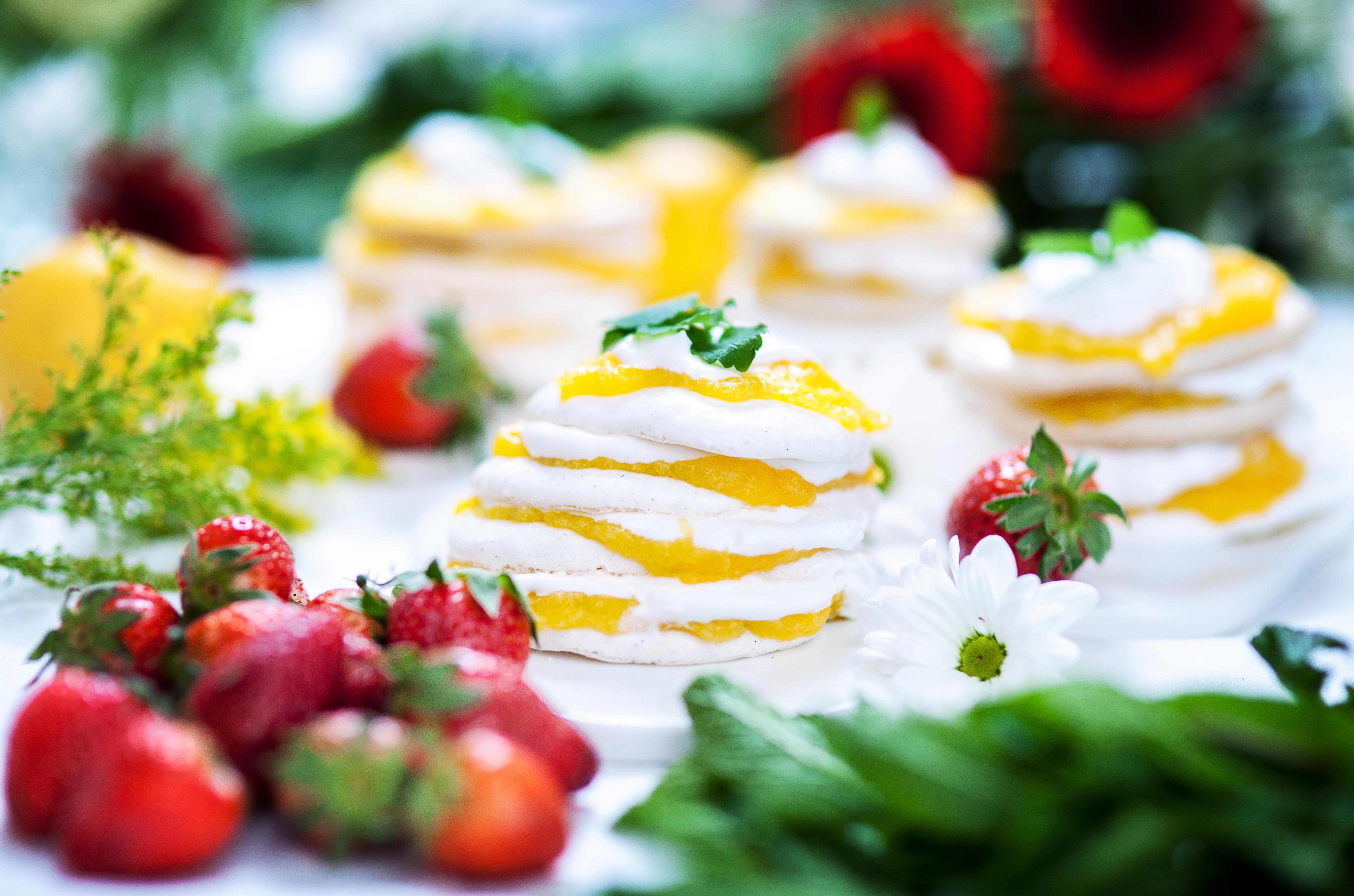 Marängtårta med mango curd, dekorerad med jordgubbar och citronmeliss.