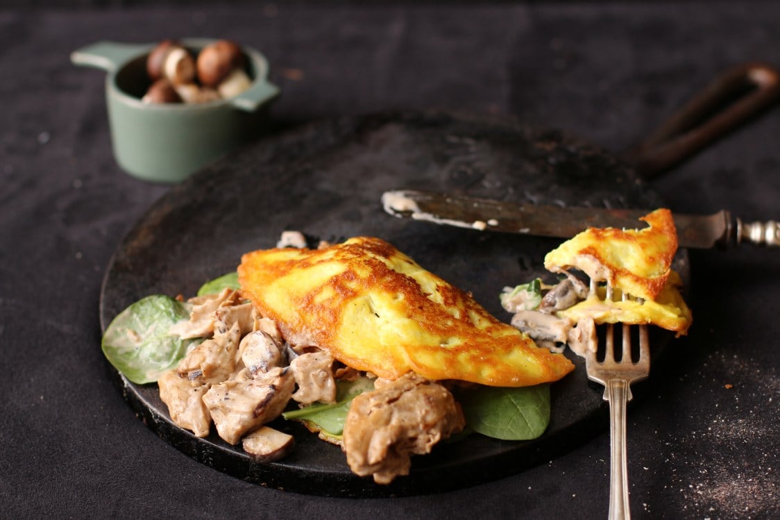 Omelette med oumph på en svart tallrik på ett svart bord.