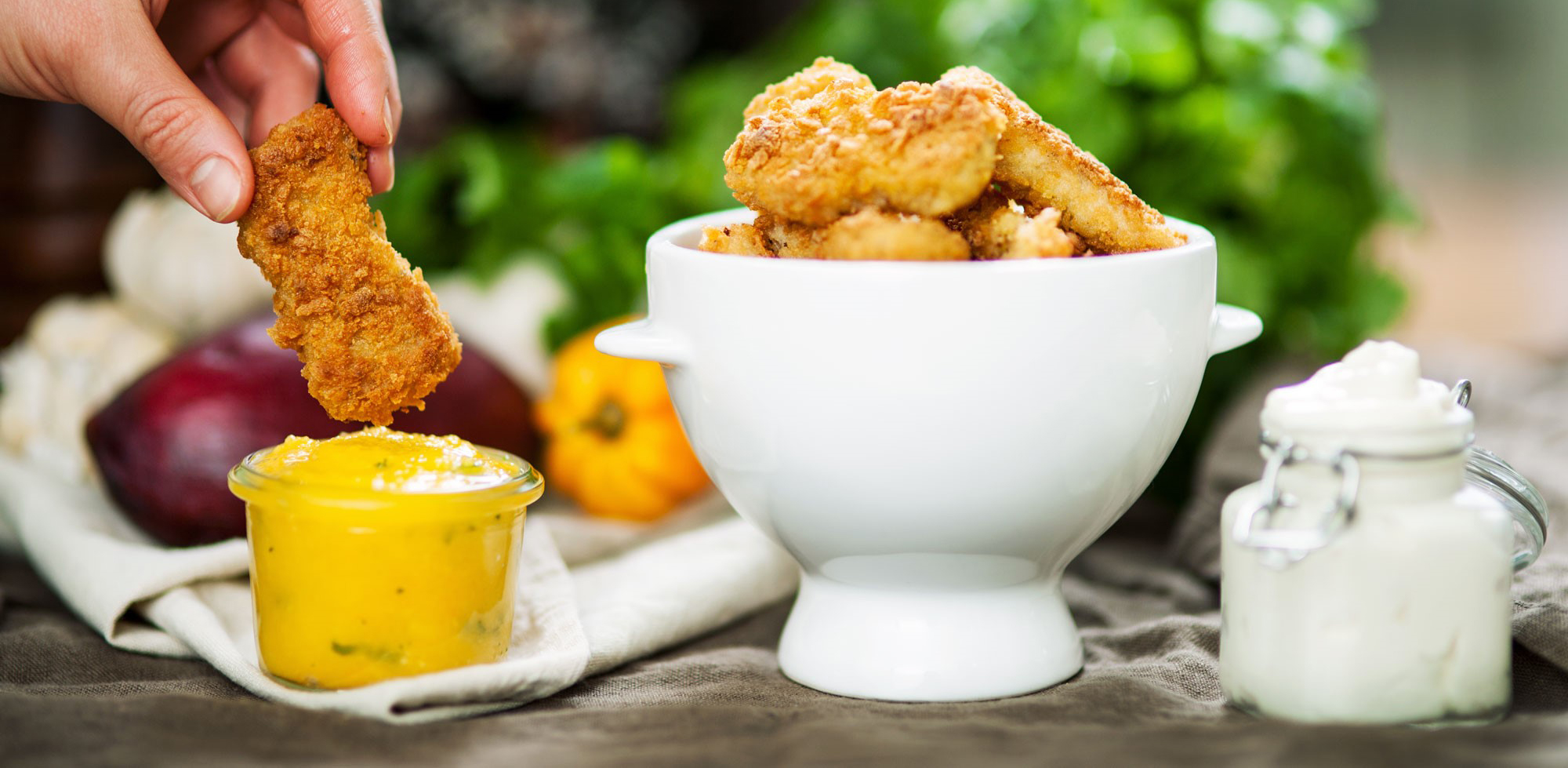 Nuggets i en vit skål, bredvid står en skål med mangosås.