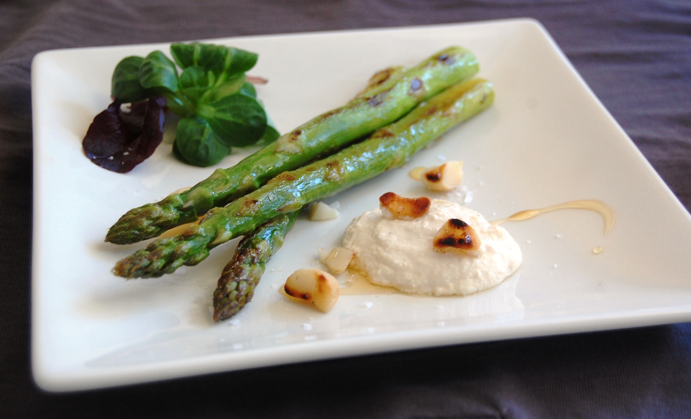 Fräst sparris med vegansk ädelostkräm på en vit tallrik.