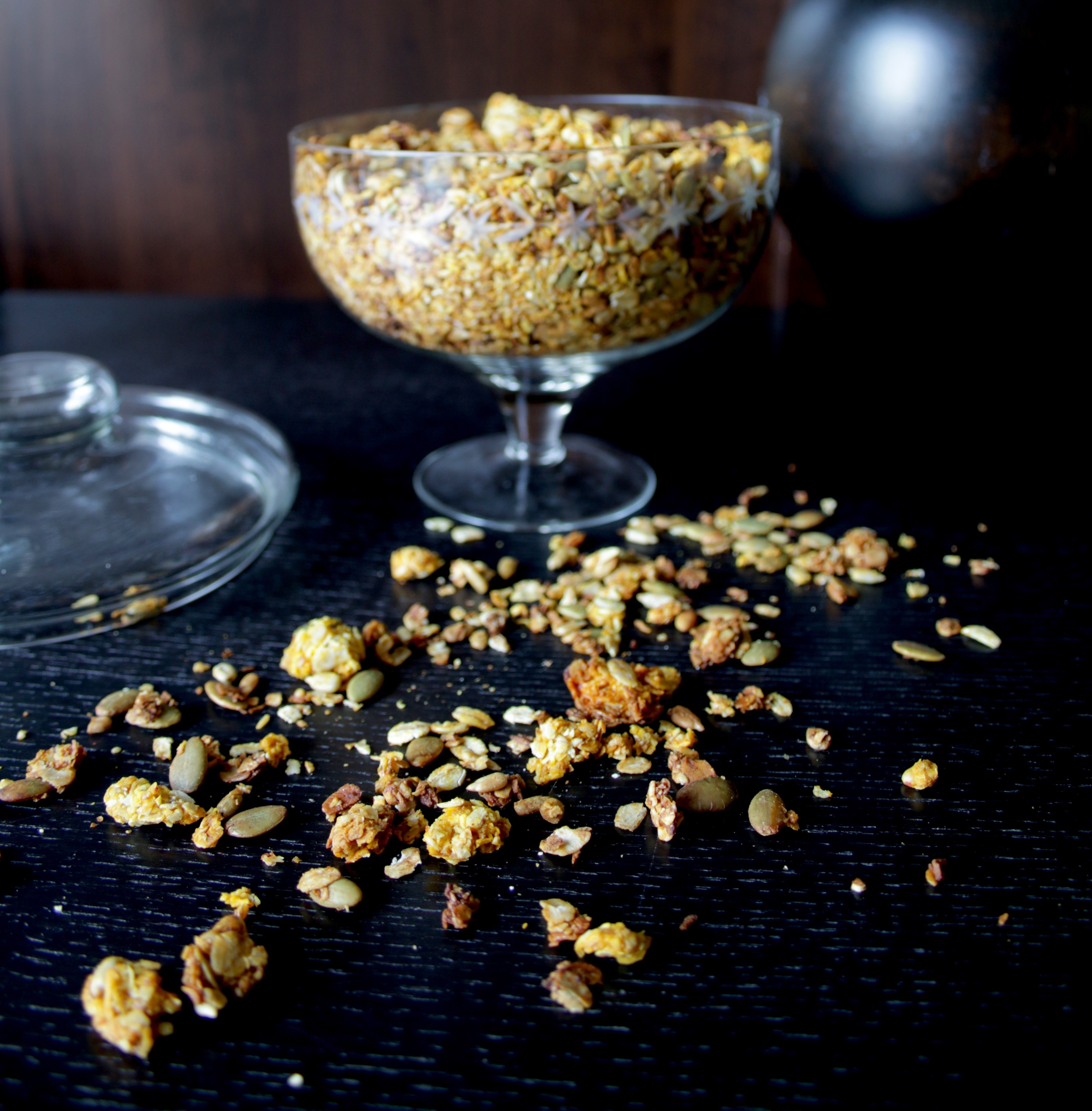 Saffransgranola i en glasbägare på ett mörkt bord.
