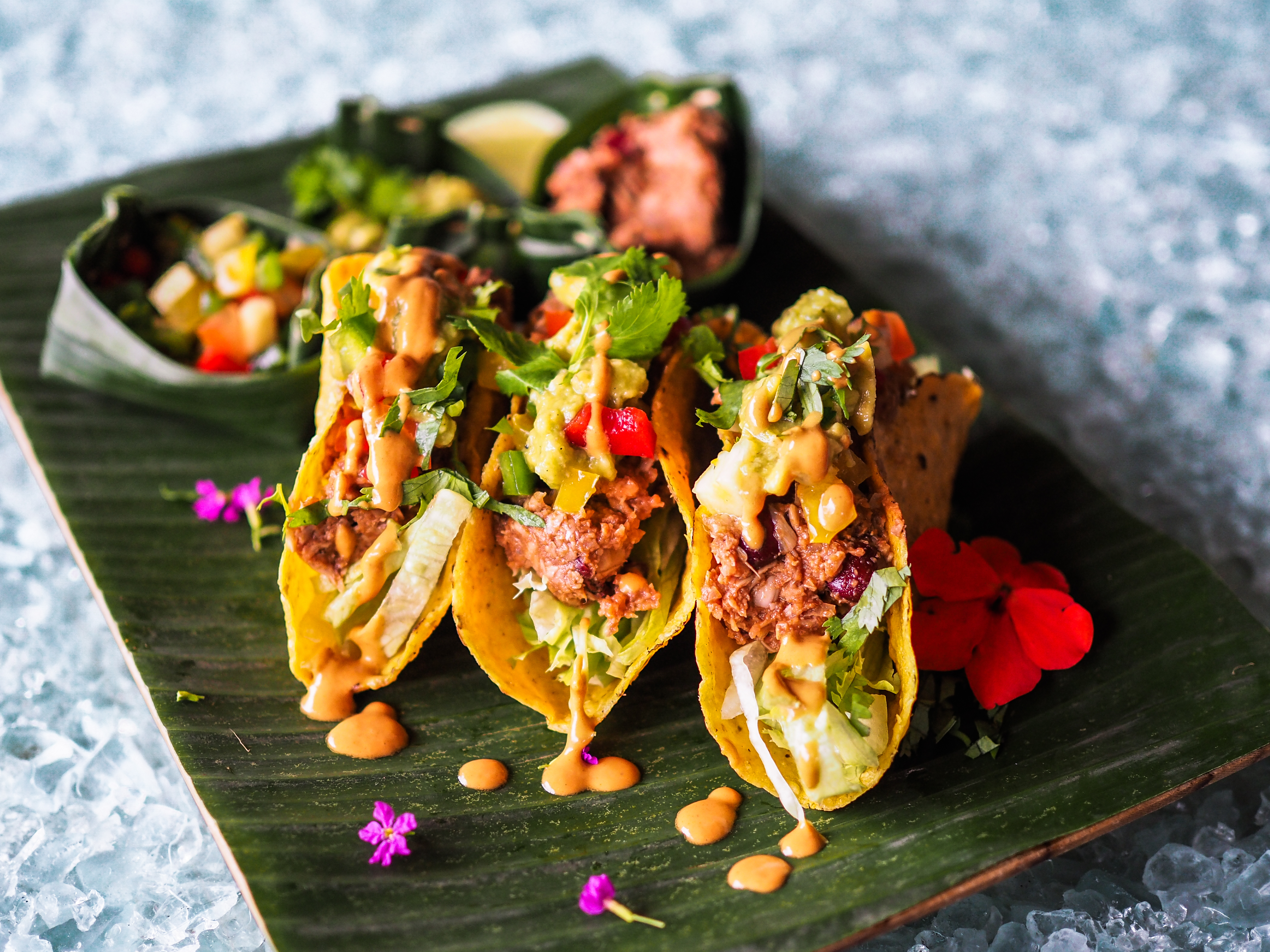 tre jackfruit tacos på en svart bräda