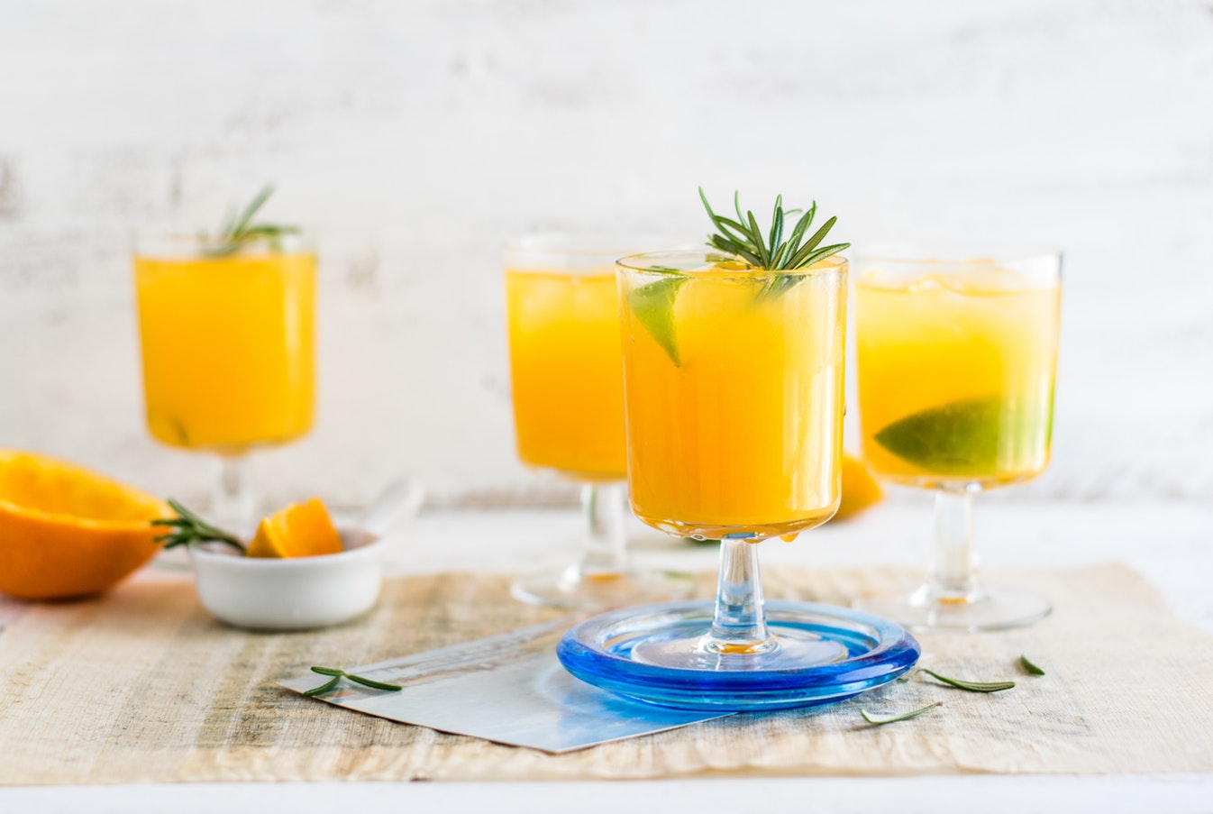 Fyra glas med juice på ett vitt bord