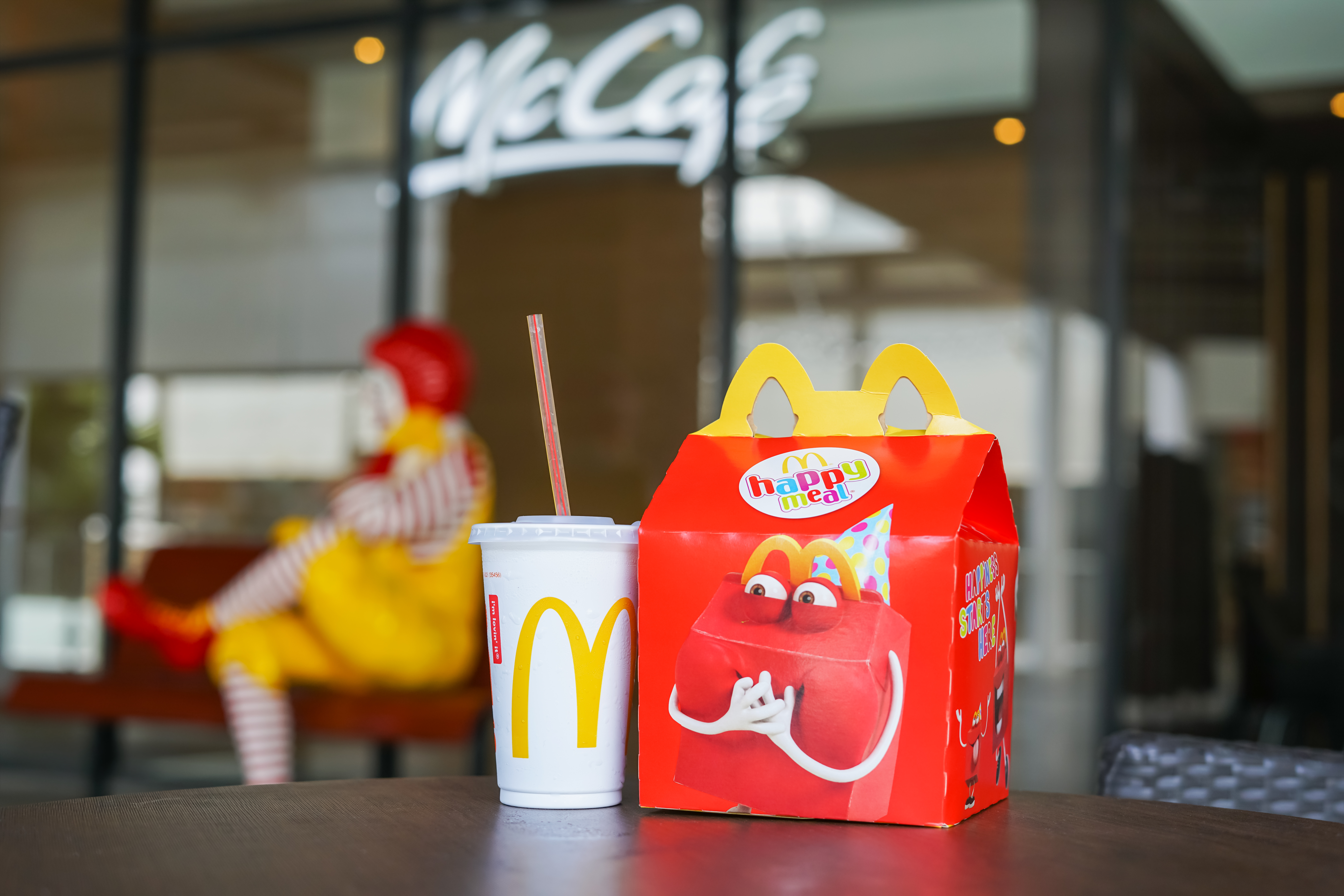 Bild på "Happy Meal" låda på ett bord med en mugg bredvid