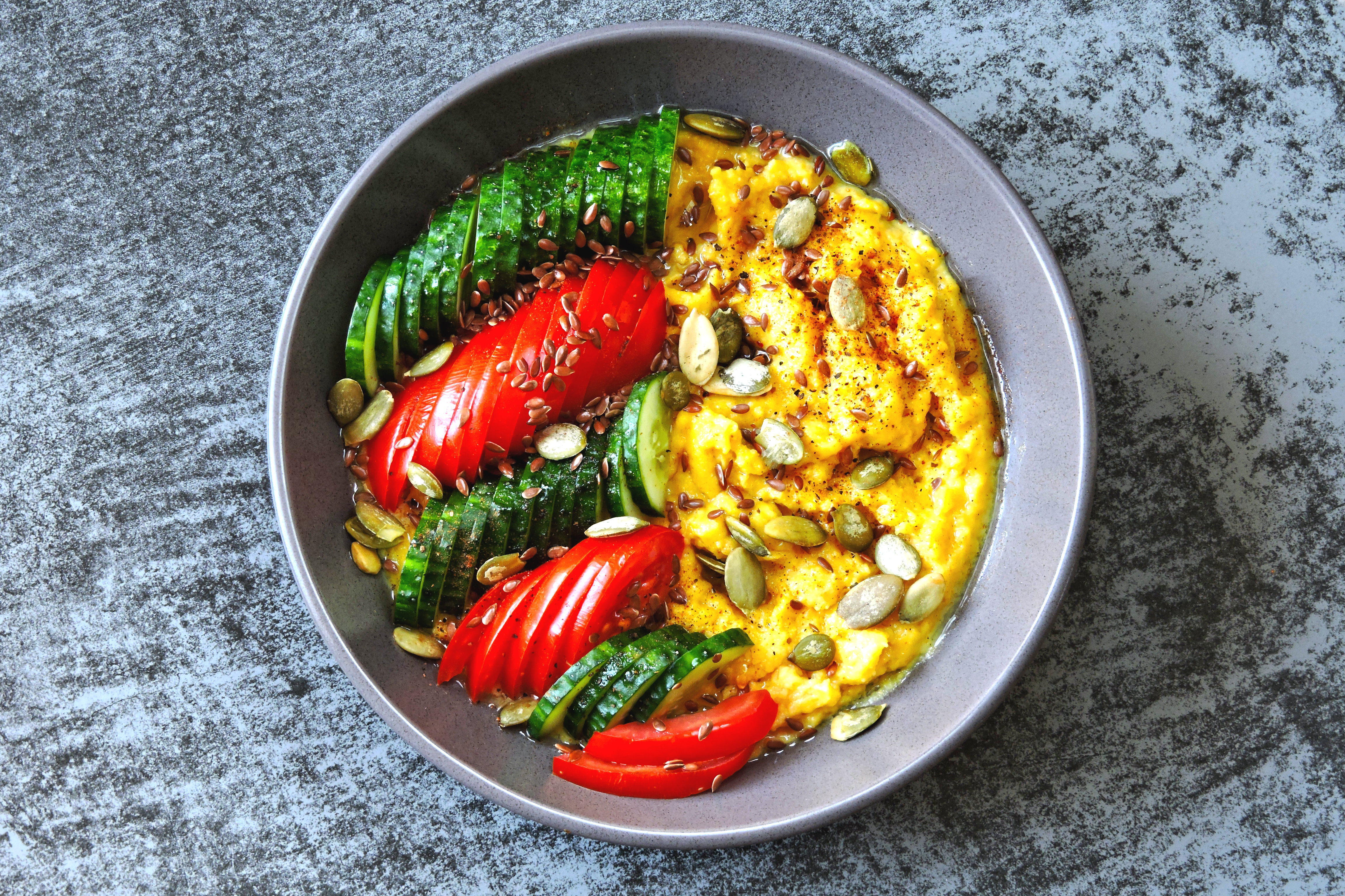 Bowl med grönsaker och polenta på ett bord