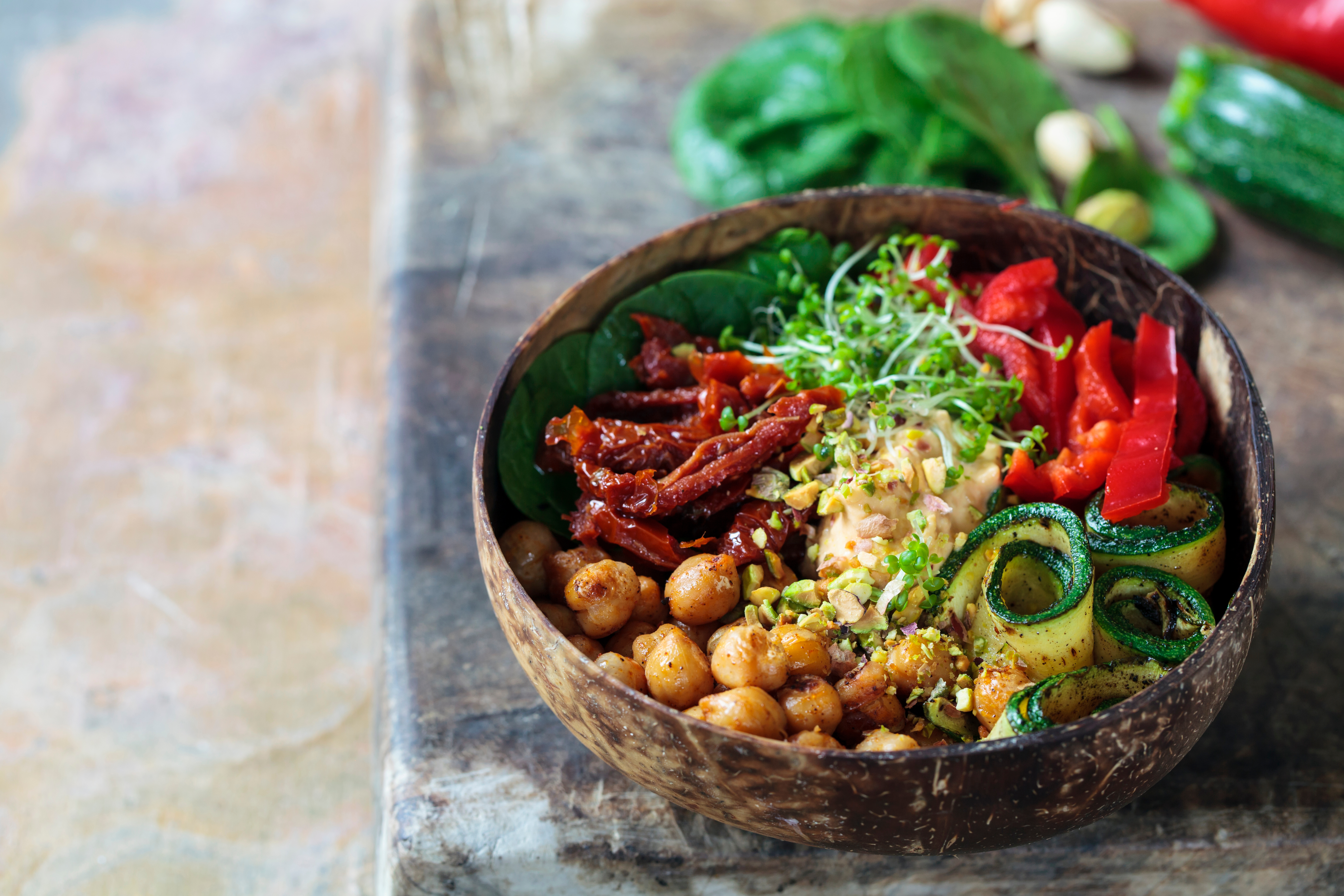 En vegansk bowl med hummus, paprika, kikärtor, krasse bland andra grönsaker.