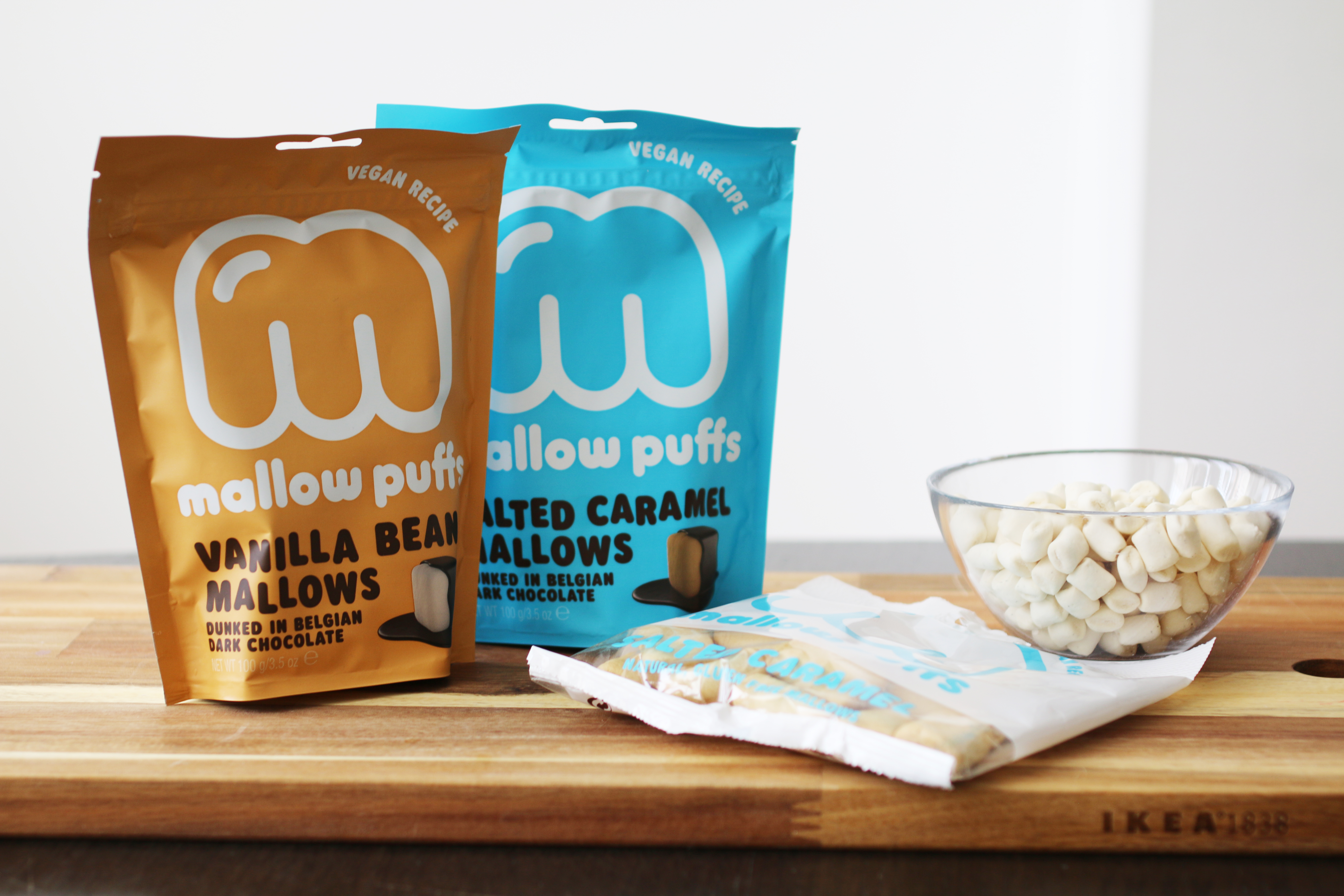 Förpackningar med veganska marshmallows på en skärbräda.
