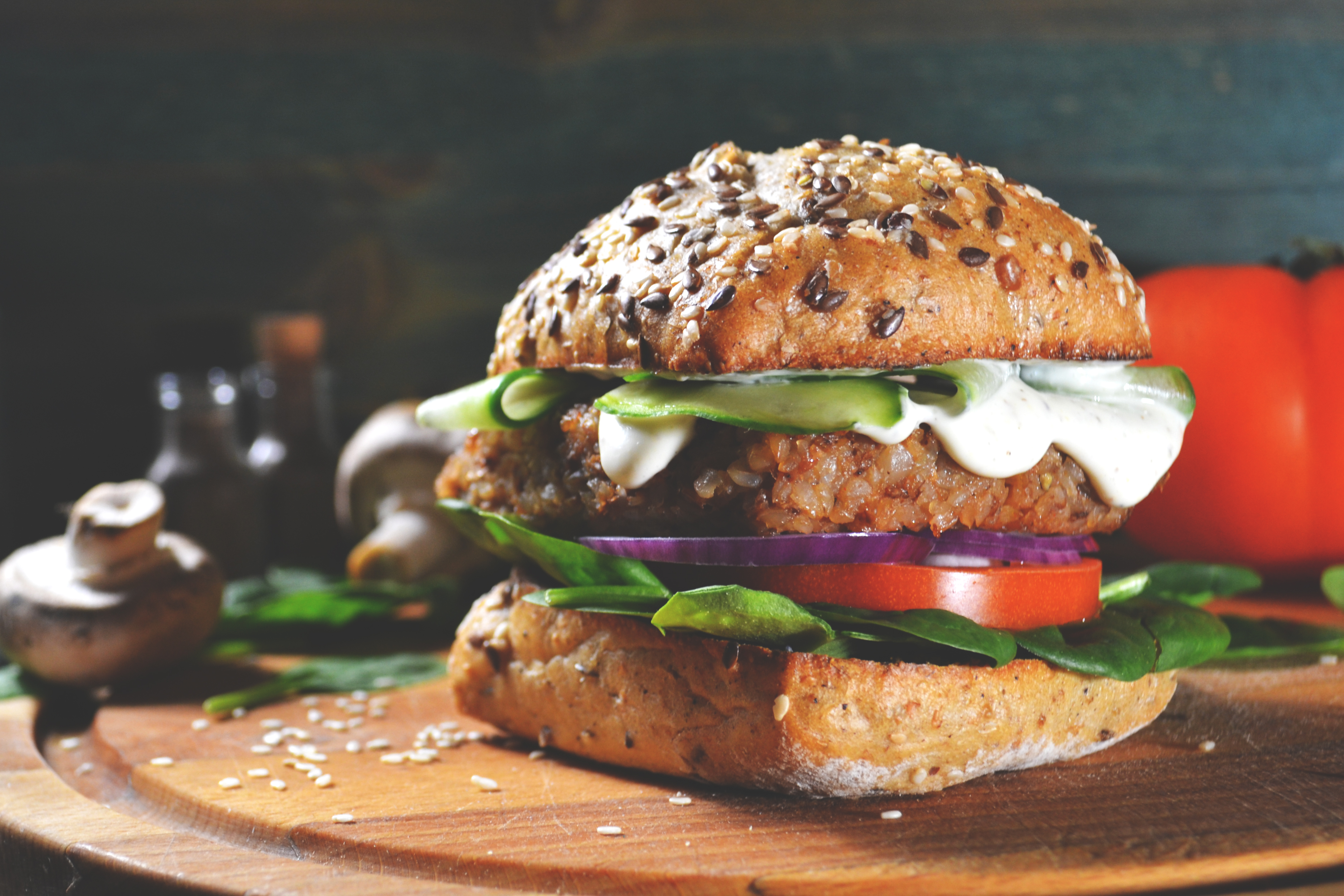 Vegansk burgare på en träbräda mot mörk bakgrund
