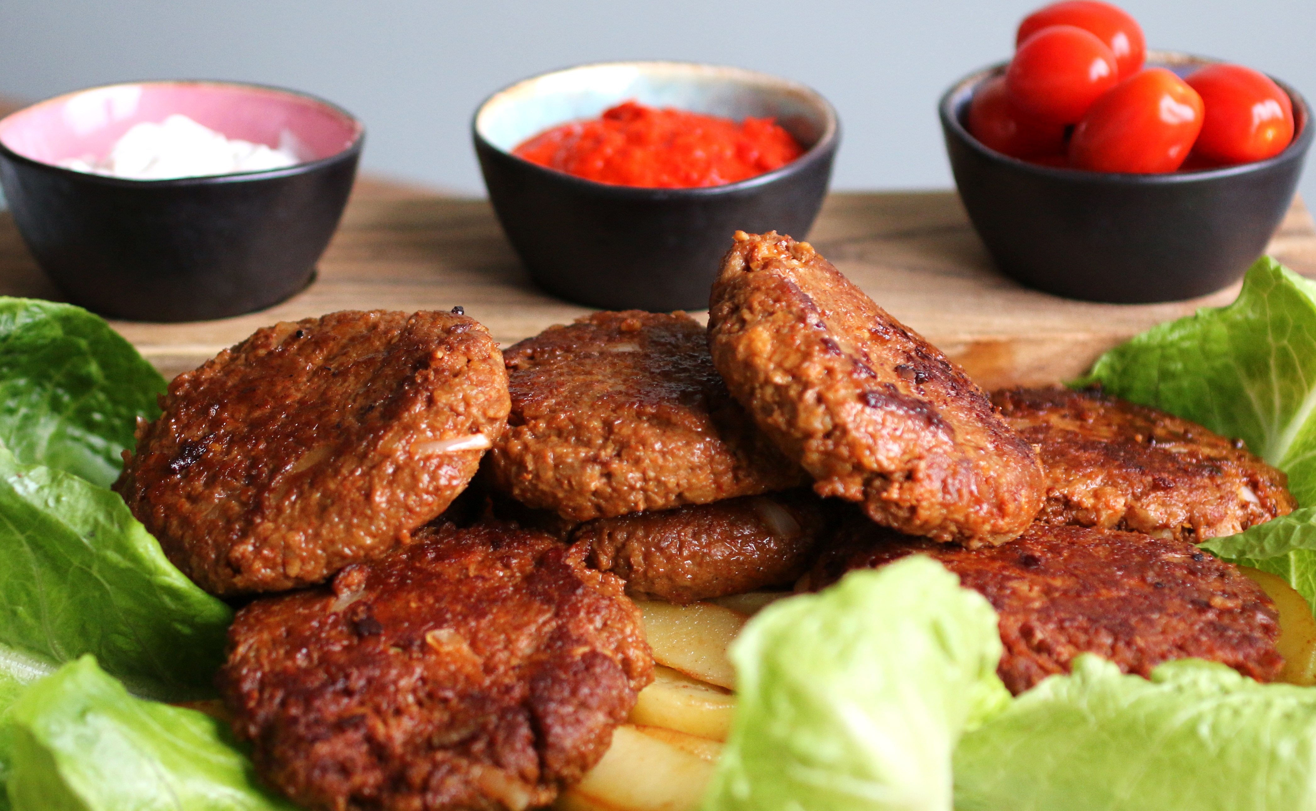 Vegansk Pljeskavica serverad med sallad och klyftpotatis