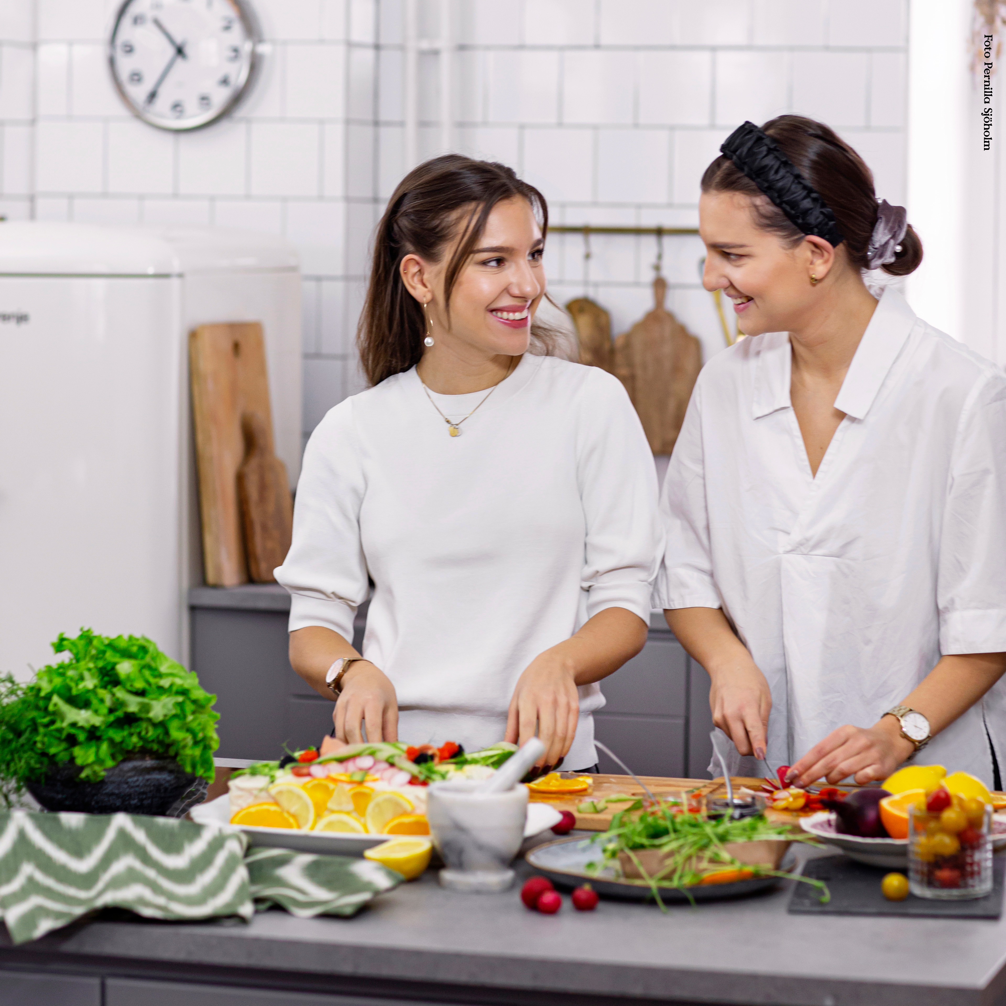 Emma och Amelia från Vegansk Matlåda står och lagar mat i ett kök
