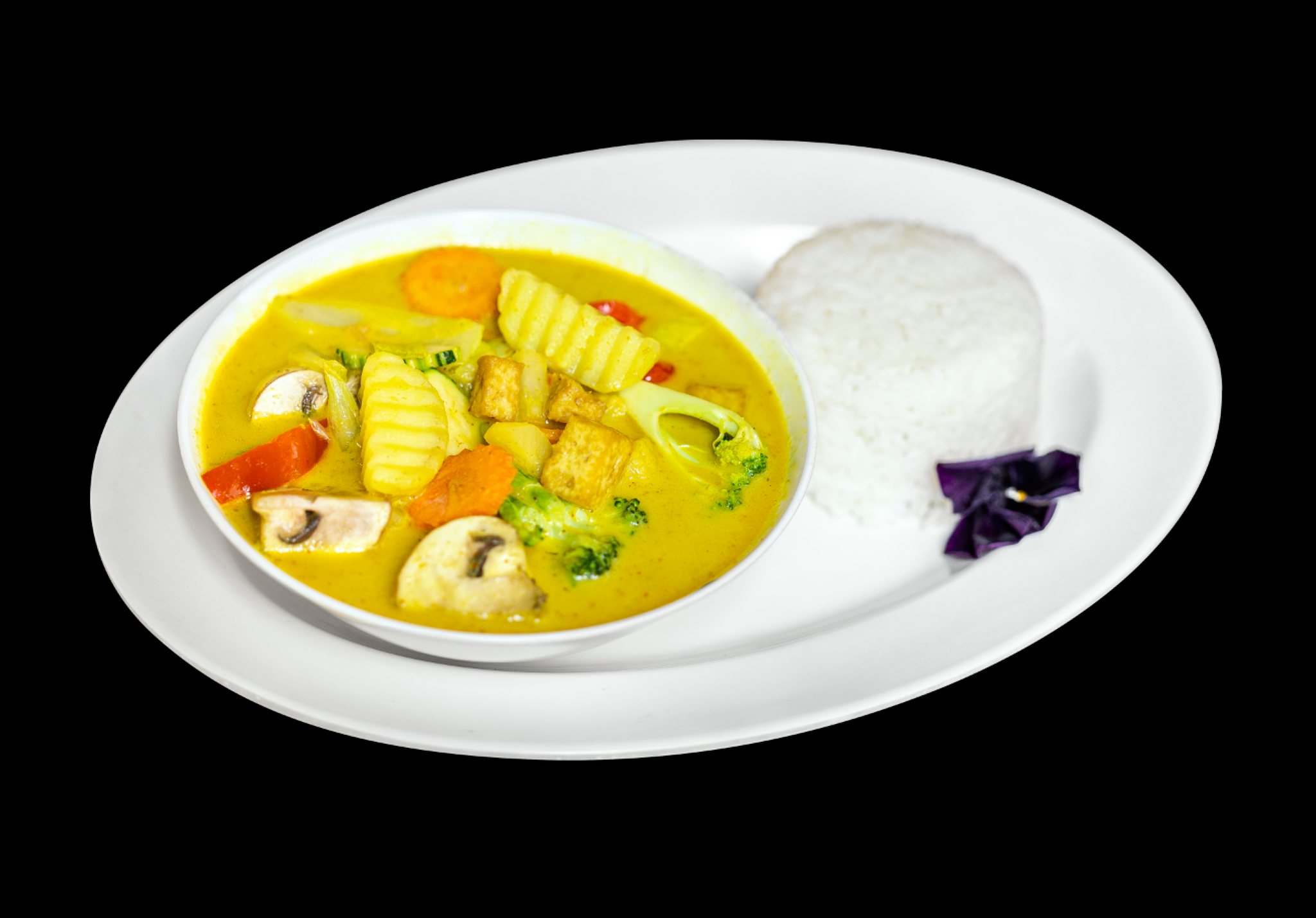 Mae Thai Stockholms veganska gula curry med tofu, grönsaker och ris på en vit tallrik med svart bakgrund.