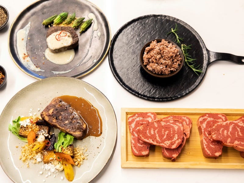 vegansk 3D kött i två olika tallrikar och en stekpanna