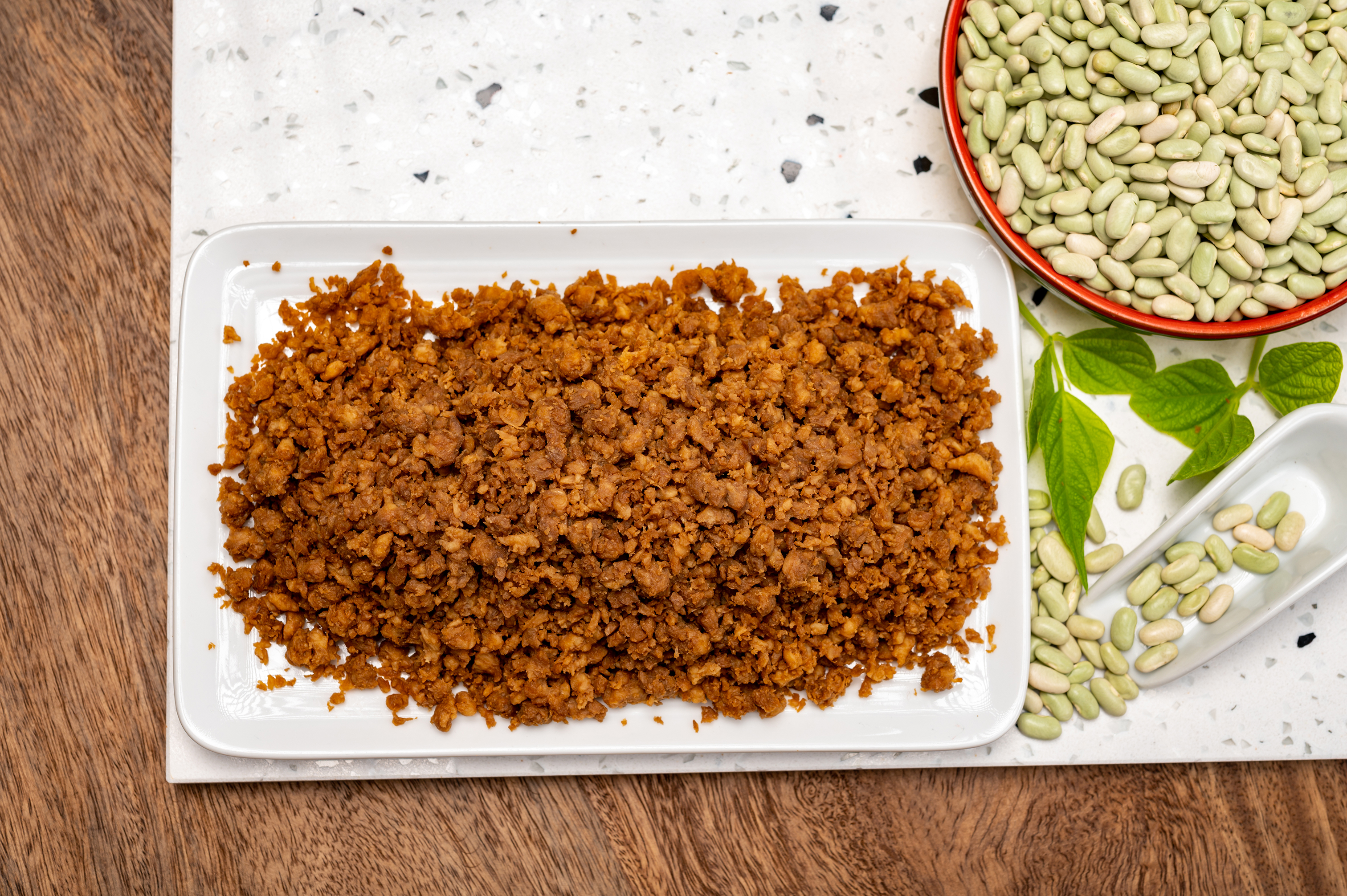 vegansk färs på en tallrik intill okokta bönor