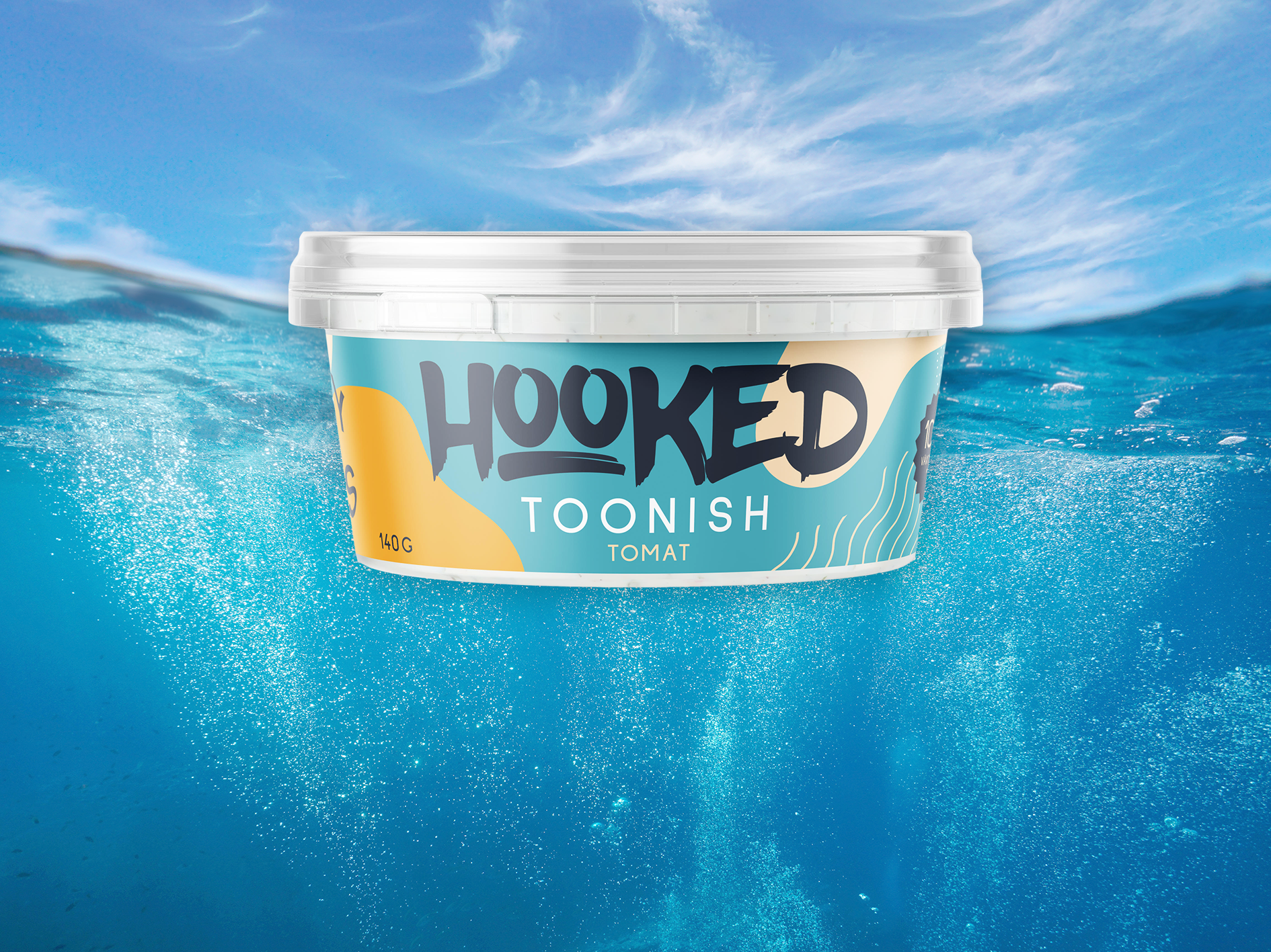 Plastburk med "Toonish" i smaken tomat mot bakgrundsfoto föreställande himmel och hab, taget delvis under vattenytan.