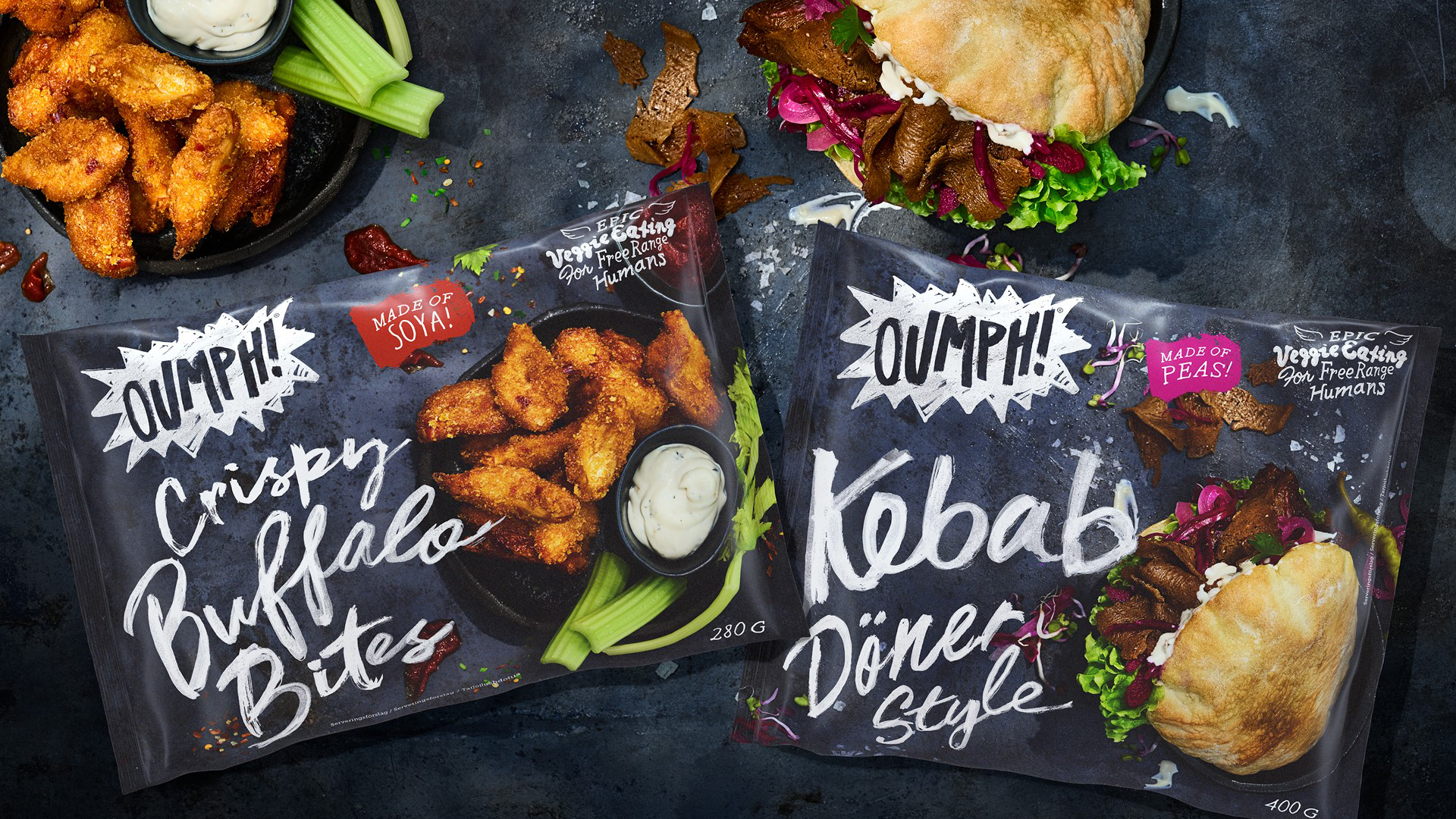 Två förpackningar med Oumph! Crispy Buffalo Bites samt Oumph! Kebab Döner Style. Vid sidan av finns produkterna upplaga för servering.