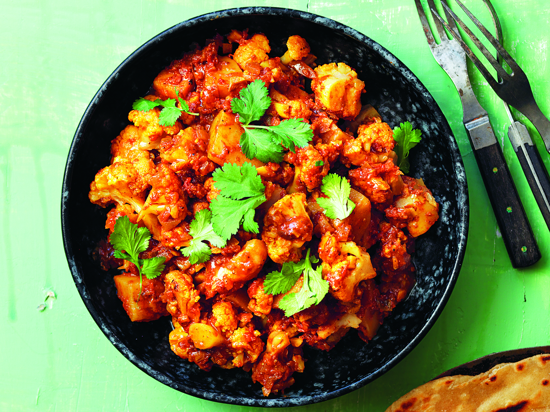 Aloo gobi i djup tallrik på bord.