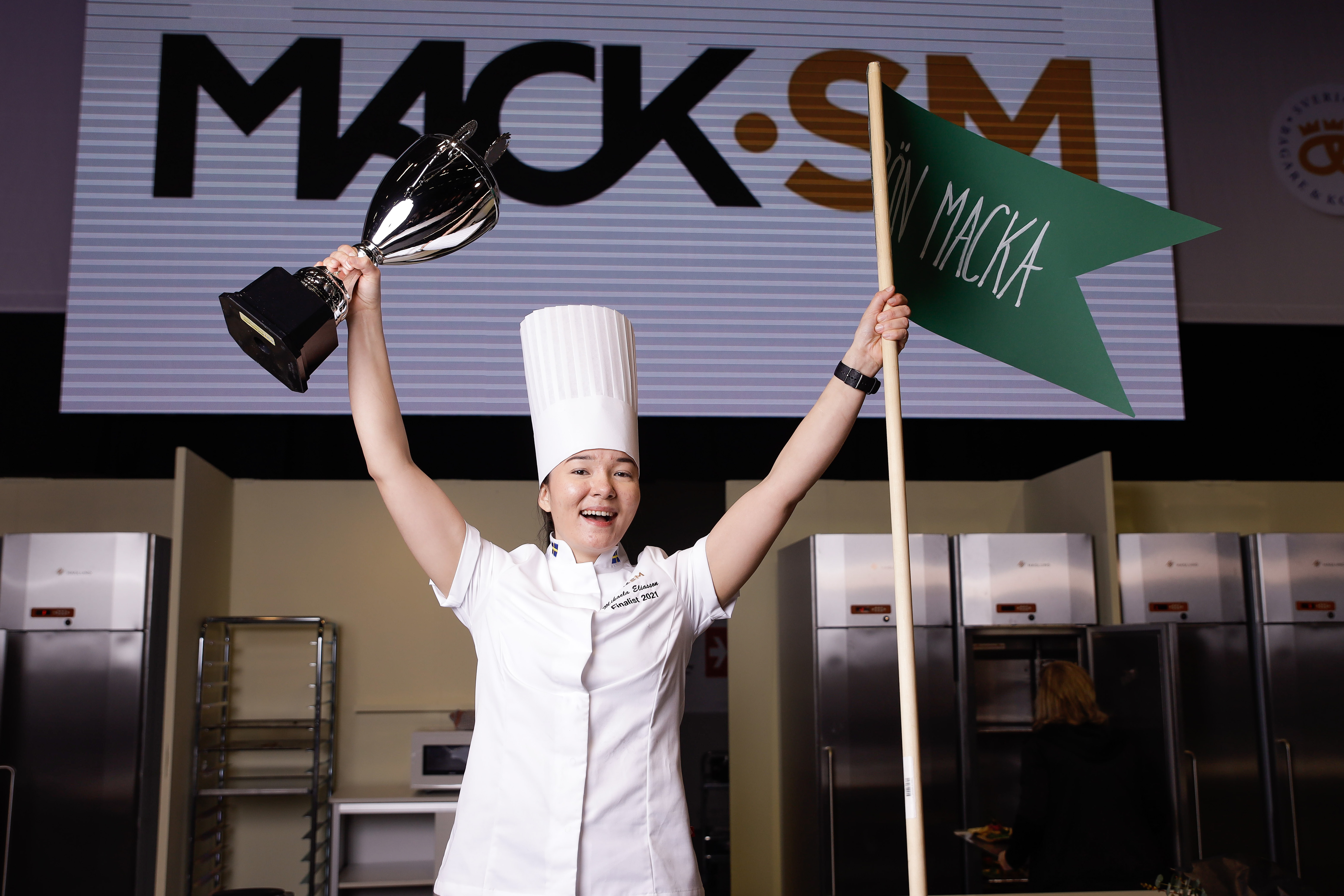Mikaela Eliasson, vinnare av Mack-SM 2021, med pokal och flagga i händerna.