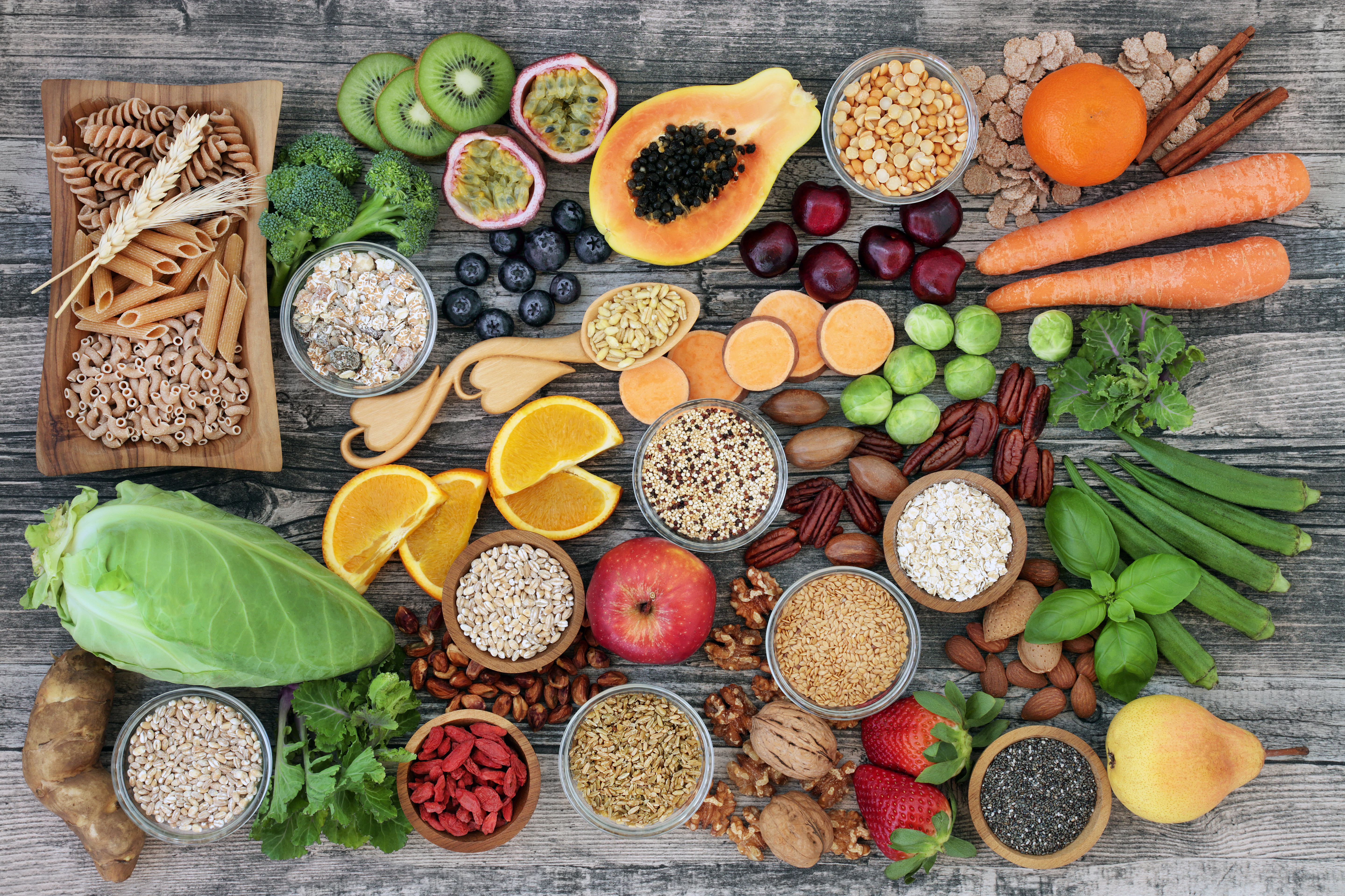 Veganska baslivsmedel, främst frukt och grönt, fotat ovanifrån på bordsyta.