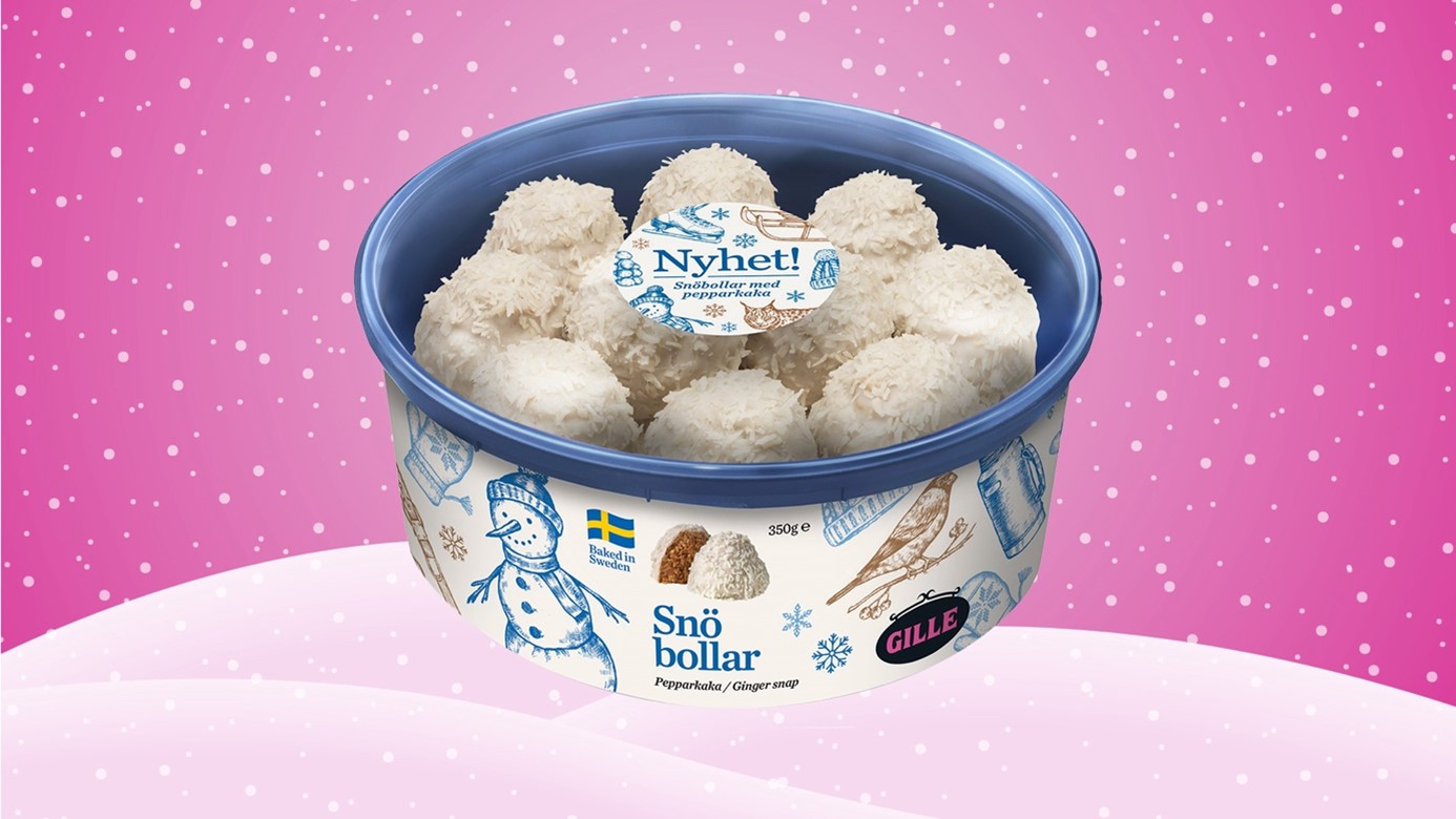 En burk med gillekakor mot en ljusrosa bakgrund med snö och snöflingor