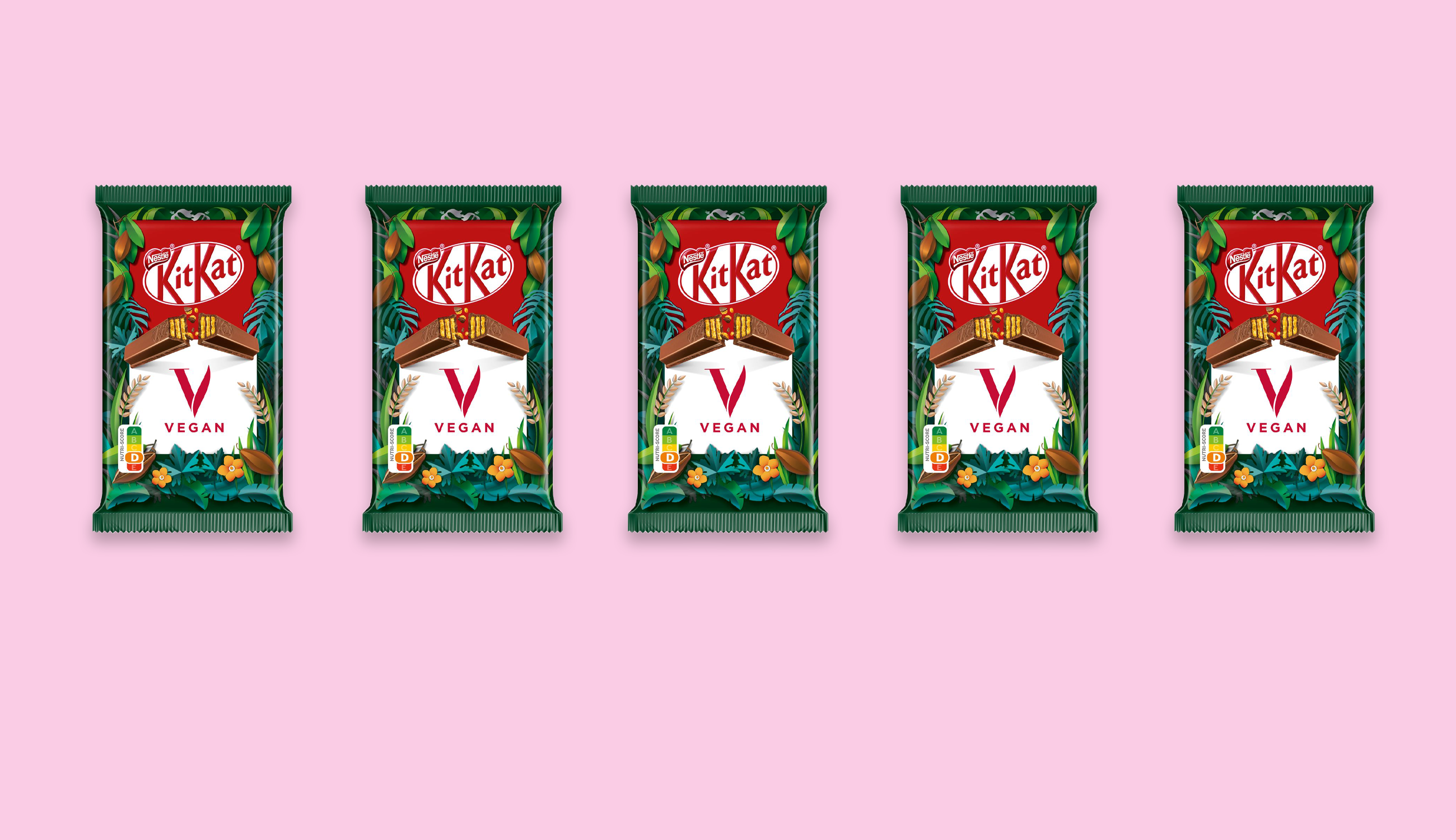 Fem veganska KitKat vegan uppradade mot en ljusrosa bakgrund.