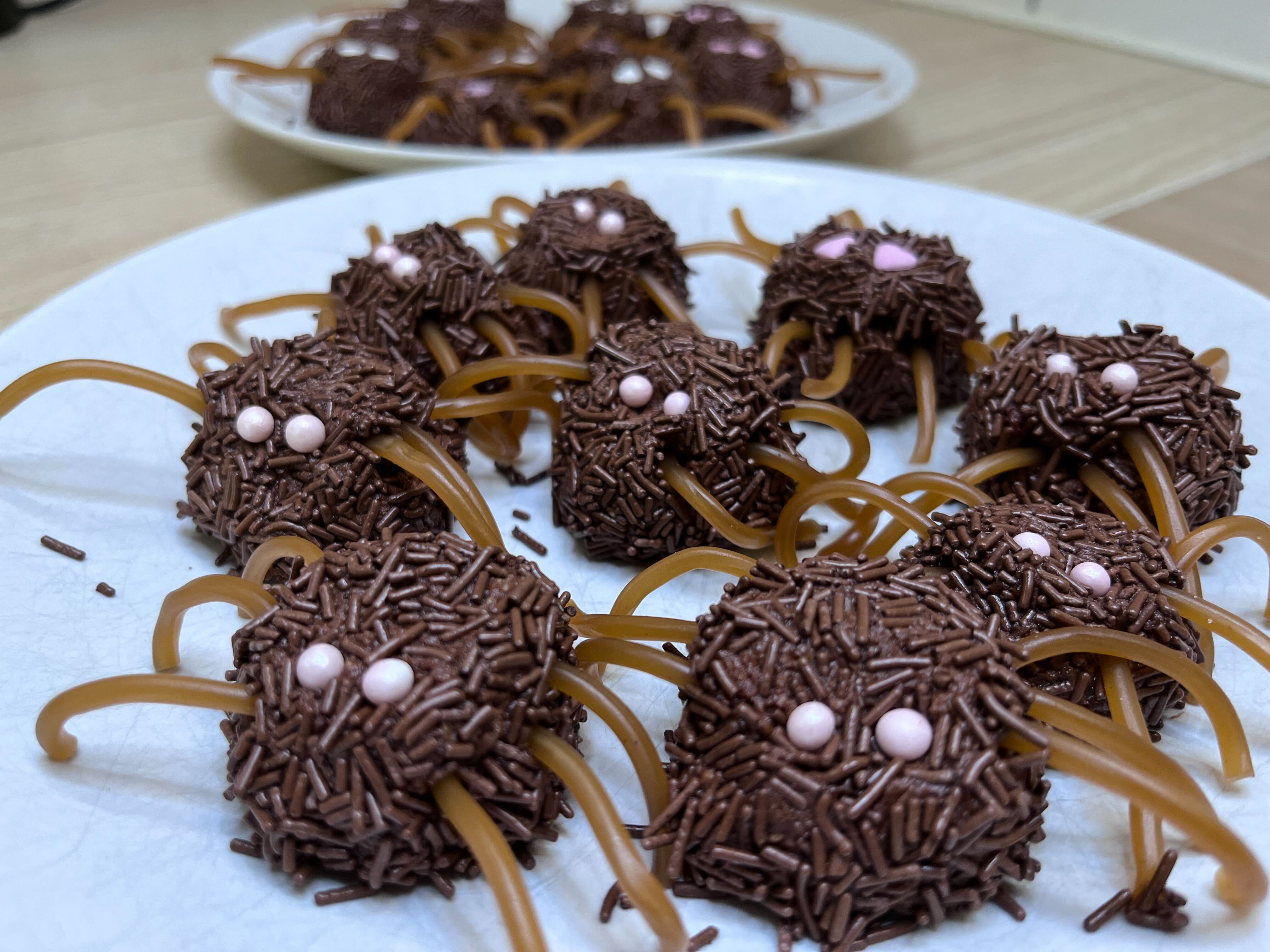 Chokladbollar som ser ut som spindlar med kolaremmar som ben och strössel som ögon