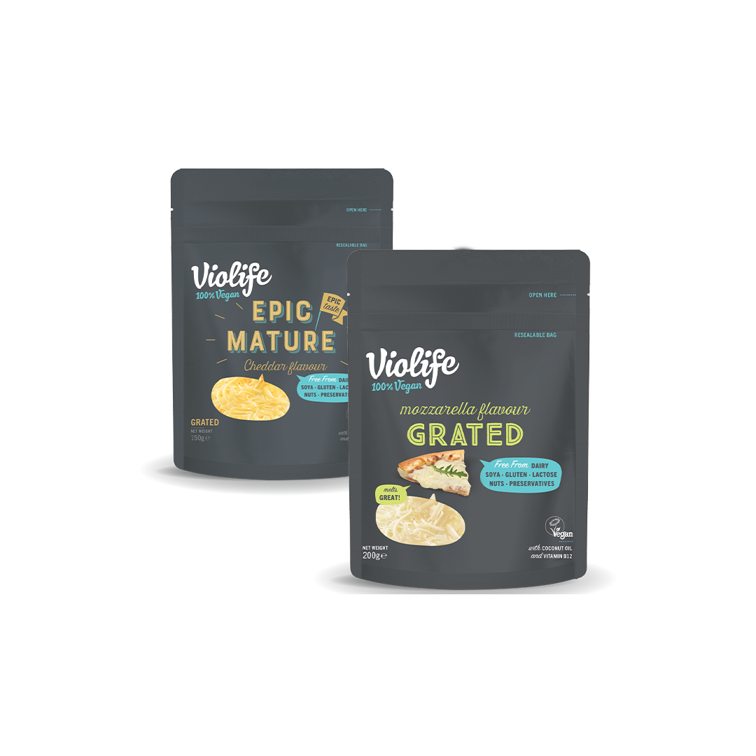 Två påsar riven vegansk ost mot en vit bakgrund.