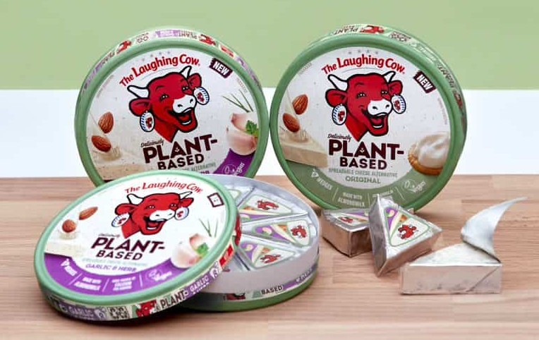 Tre hjul med vegansk mjukost i uppställda på ett träbord mot en ljusgrön vägg