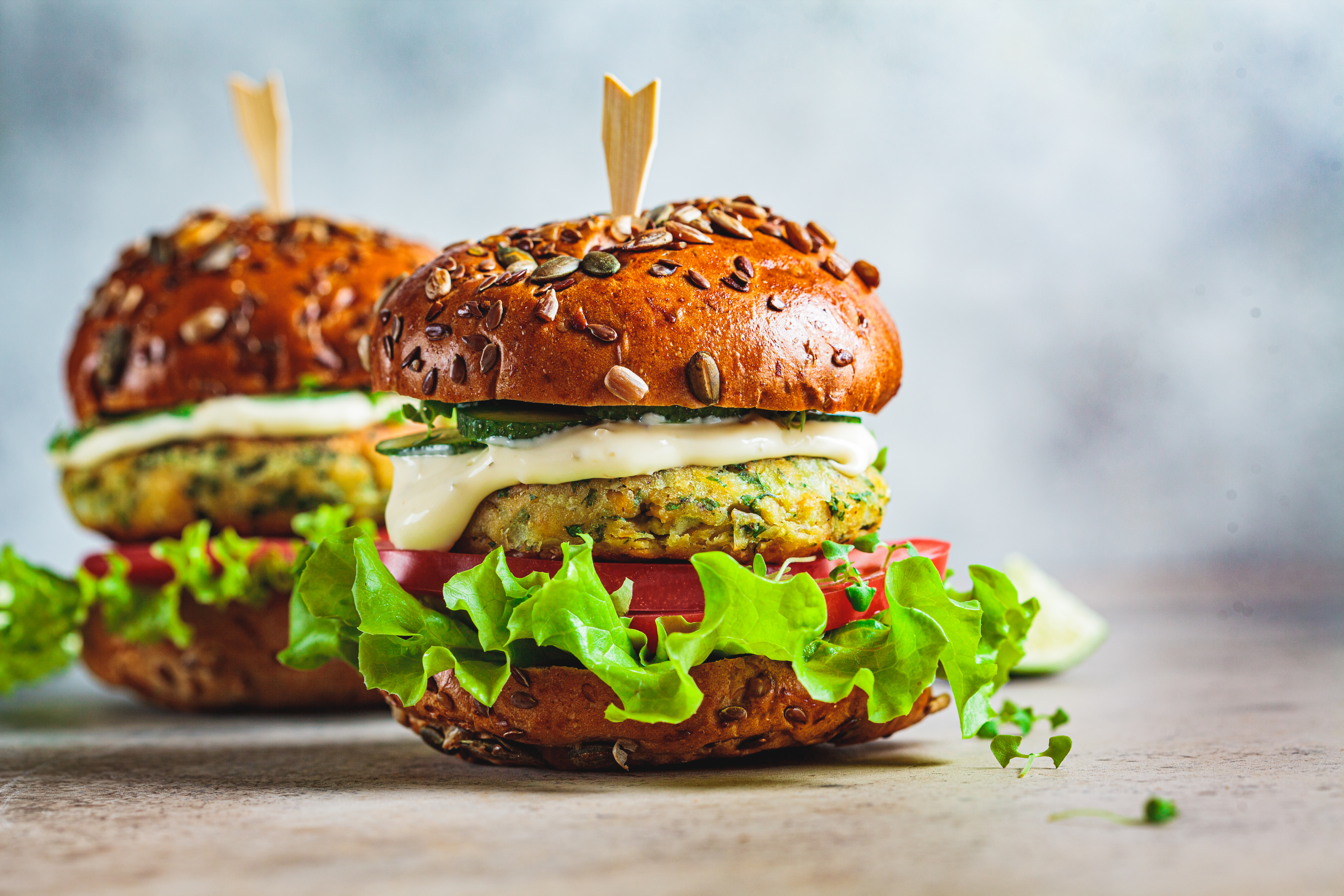 Vegan falafel burger med grönsaker och sås, mörk bakgrund. Hälsosam mat koncept.