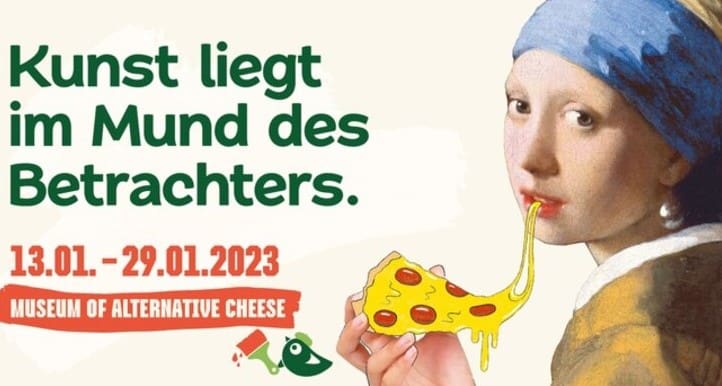 Flickan med pärlörhänget äter en pizzaslice med veganost på