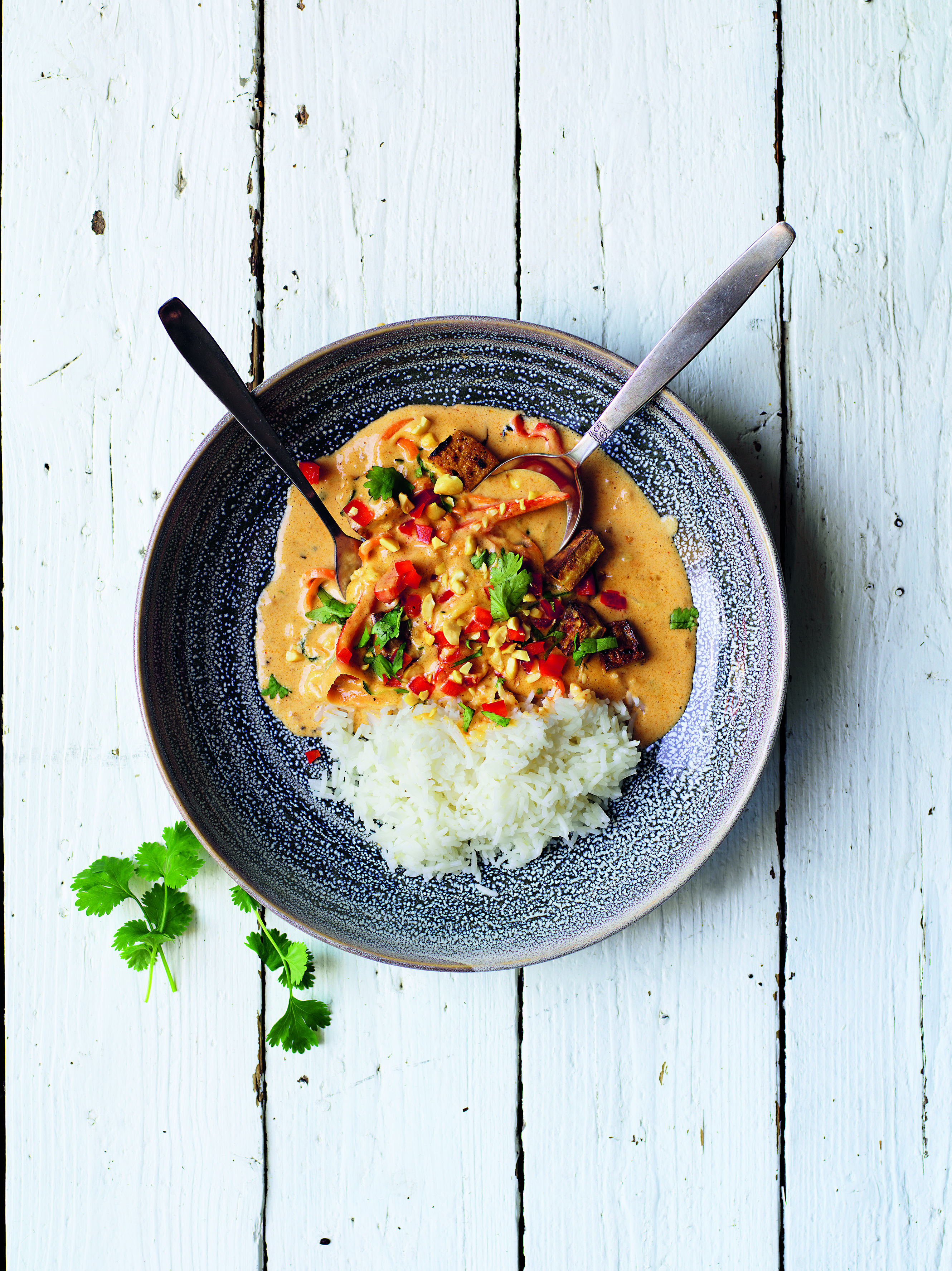 Jordnötsgryta med tofu i en djuptallrik på ett vitt bord