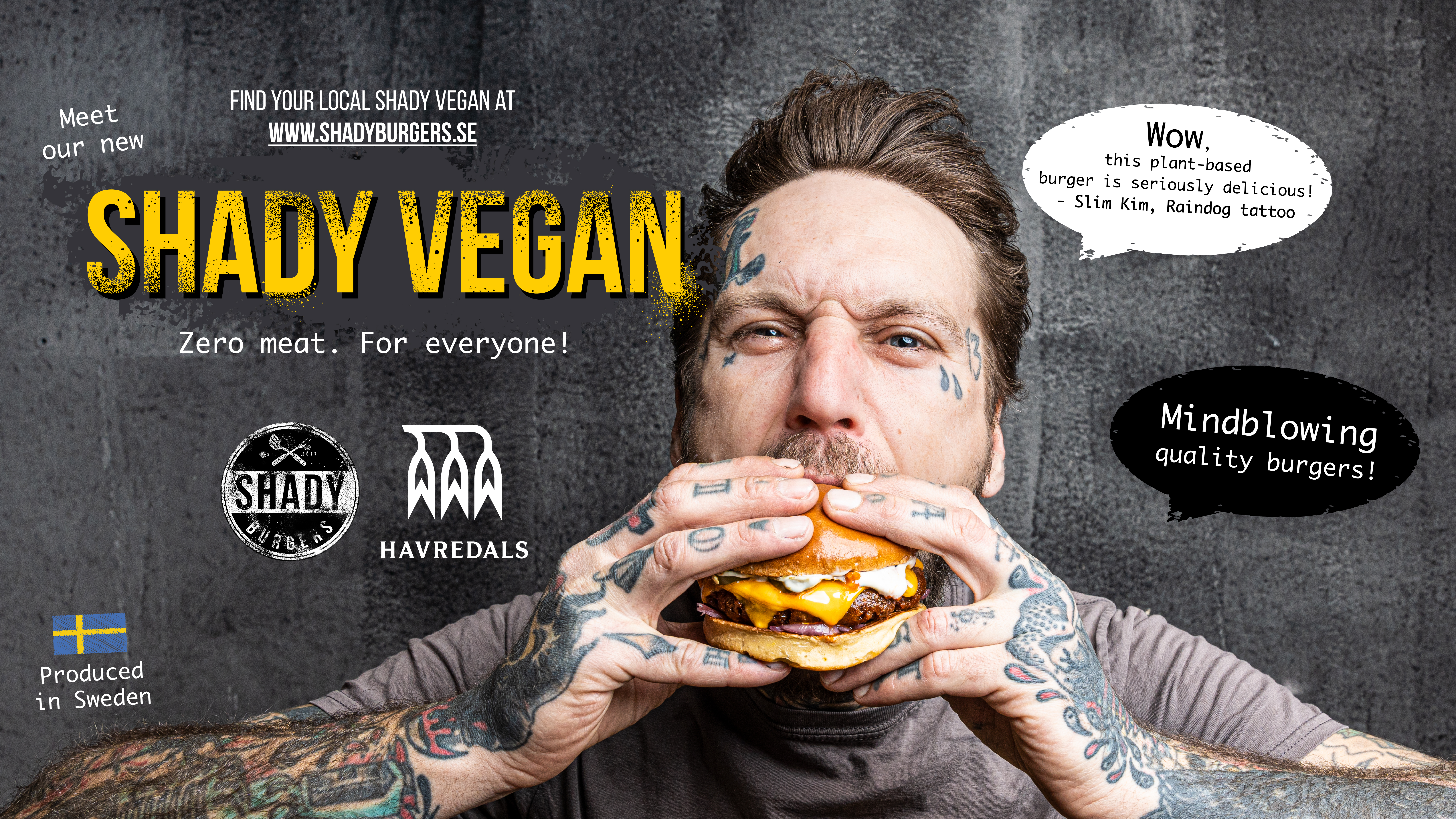 Tatuerad man som äter en vegansk hamburgare mot en mörk bakgrund