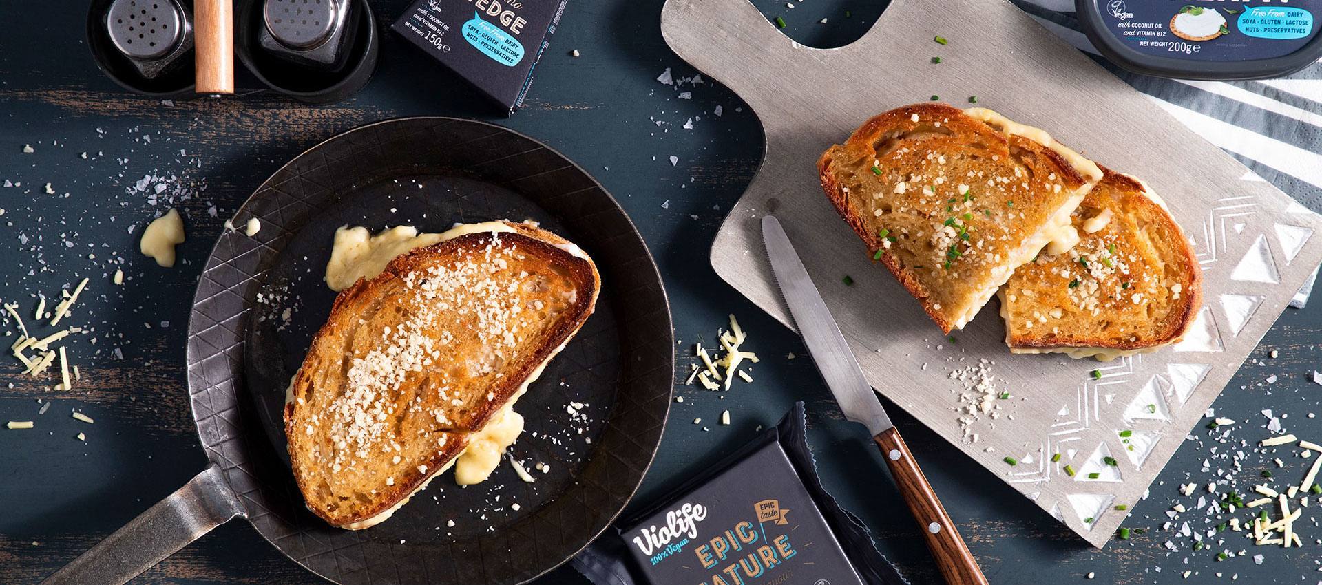 Vegansk toast i en stekpanna och en på en skärbräda