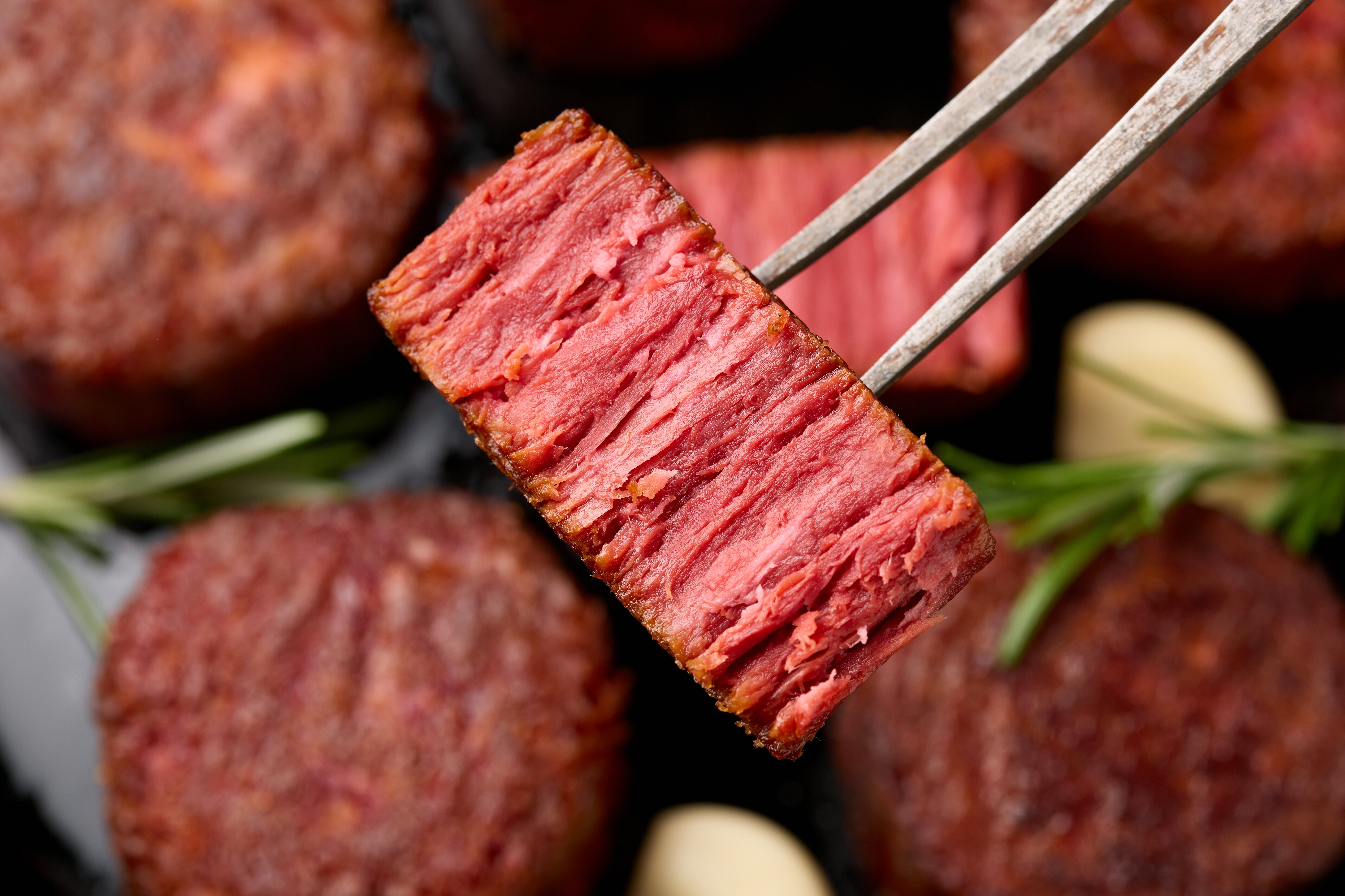 Slices of plant based vegan meat steak on meat fork. Alternatives meat. Eco friendly healthy food,