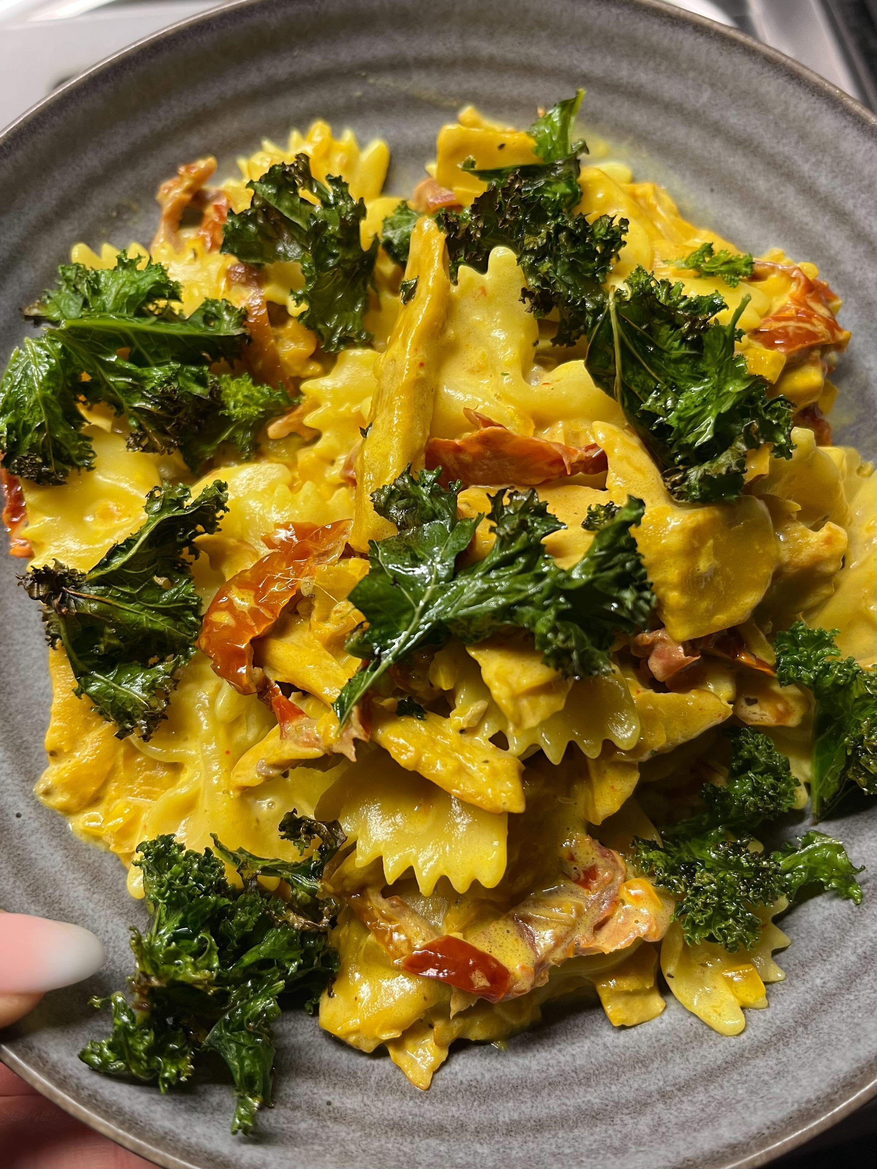 En djuptallrik med saffranspasta, grönkål och soltorkade tomater