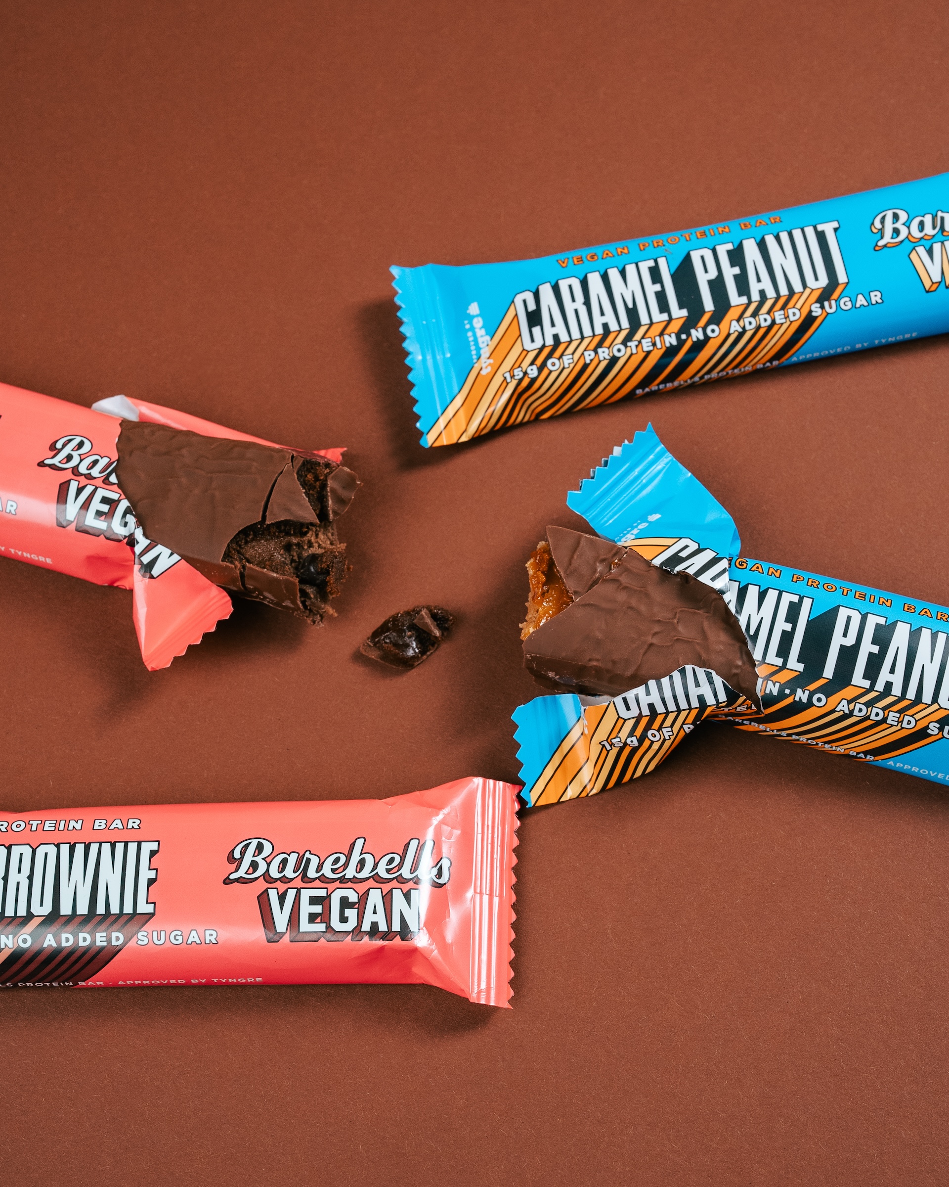 Fyra veganska proteinbars på ett brunt bord