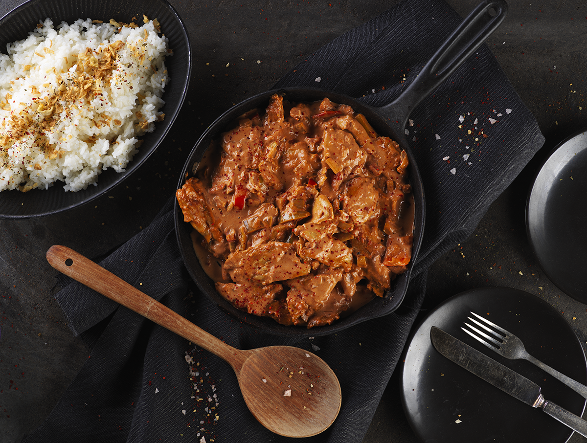 Vegansk stroganoff i en gryta på ett svart bord