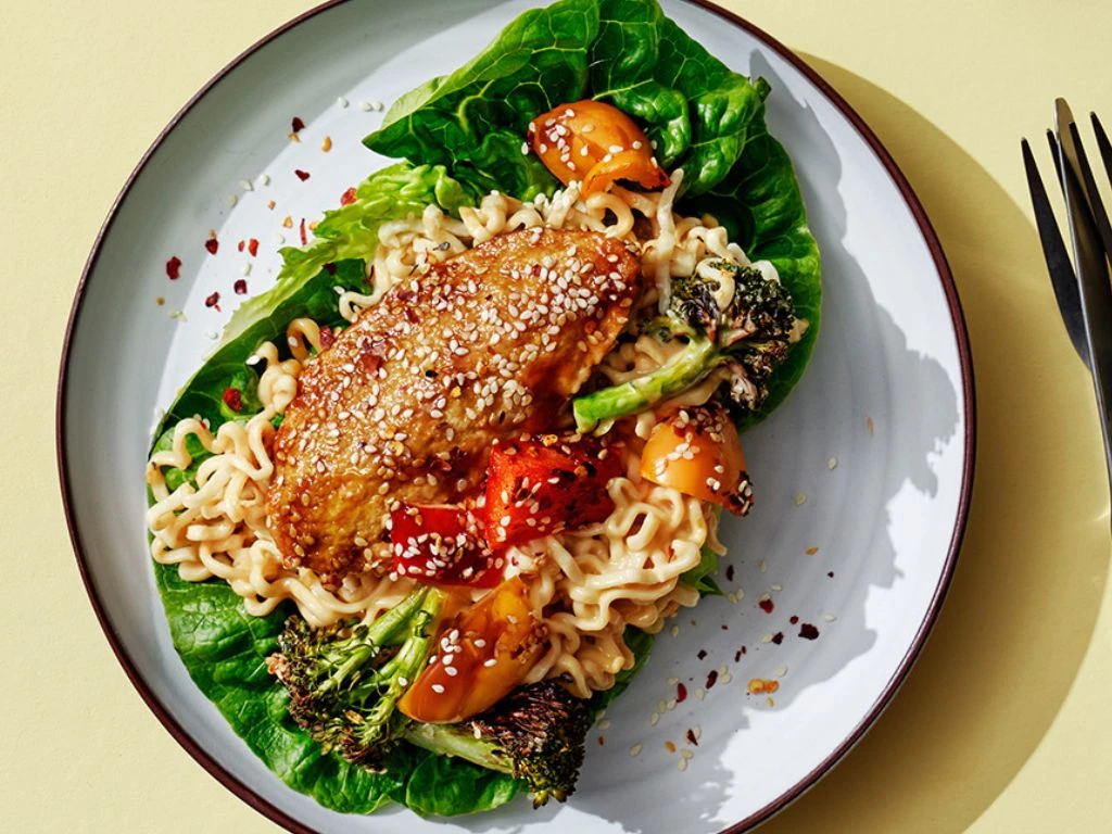 Vegofiléer med med nudlar och sallad på en tallrik, på ett gult bord