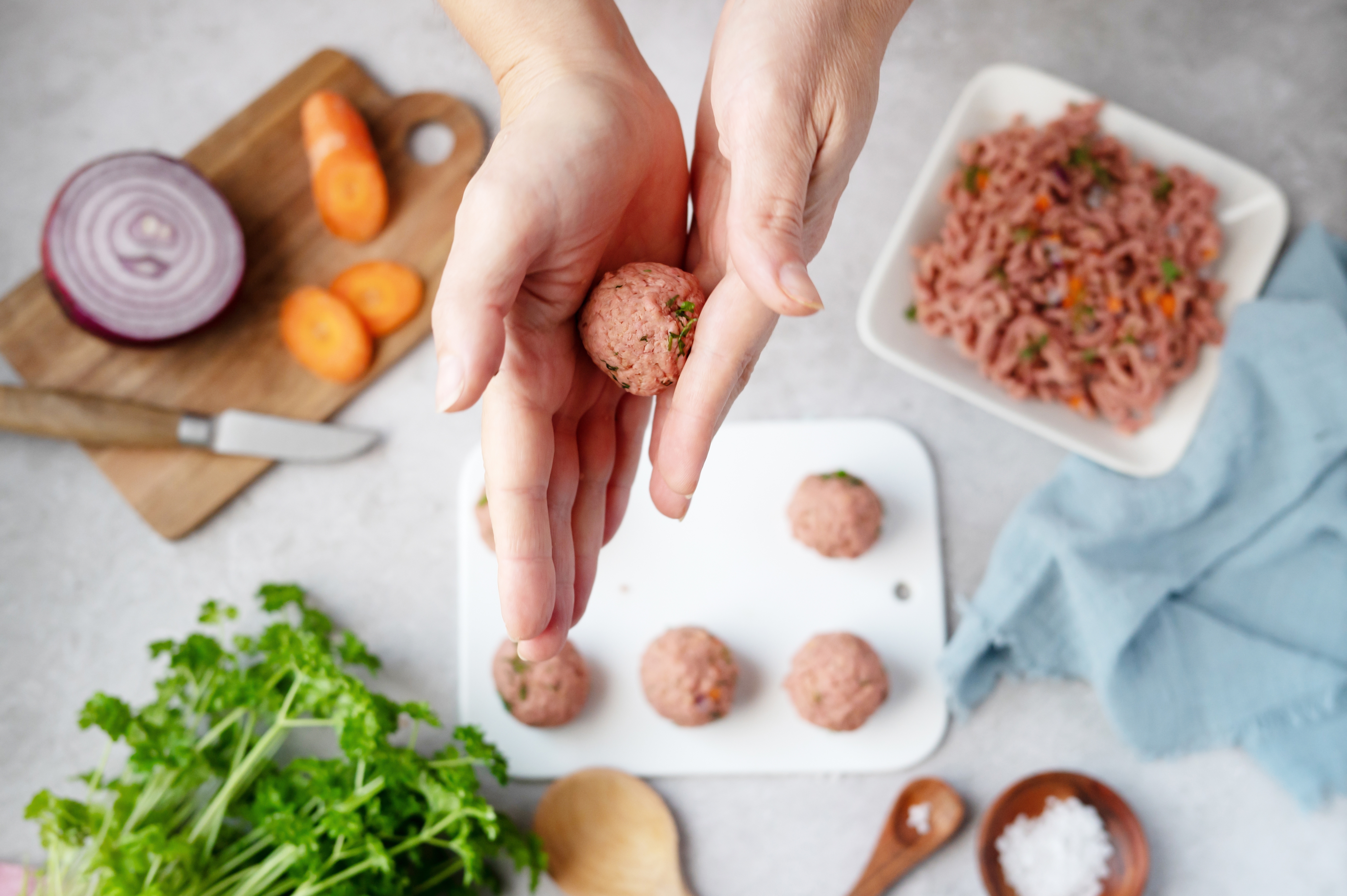 Kvinna som rullar växtbaserade köttbullar