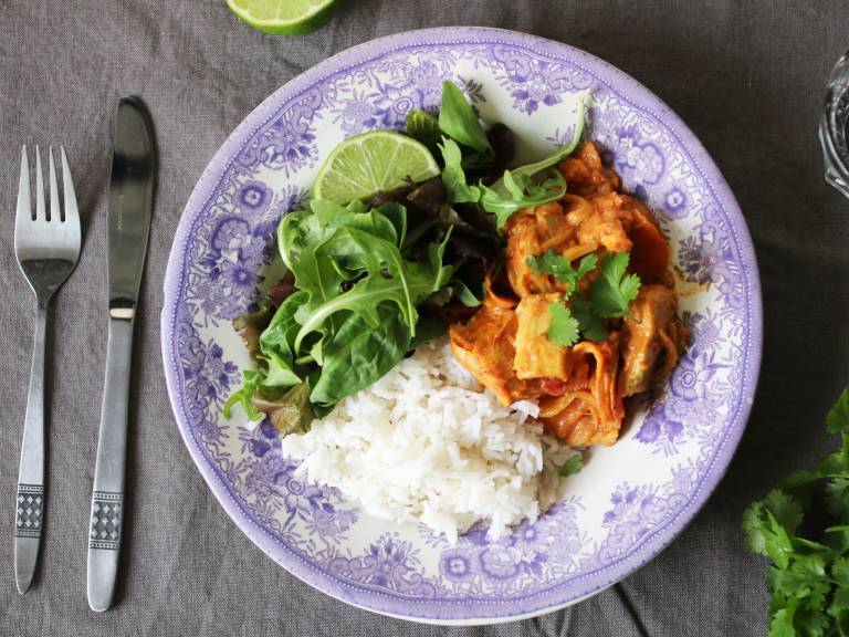 Tallrik med vegansk tikka masala, ris och grönsaker 