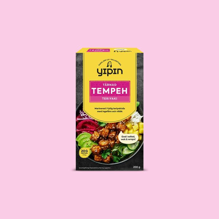 en förpackning tempeh mot en ljusrosa bakgrund