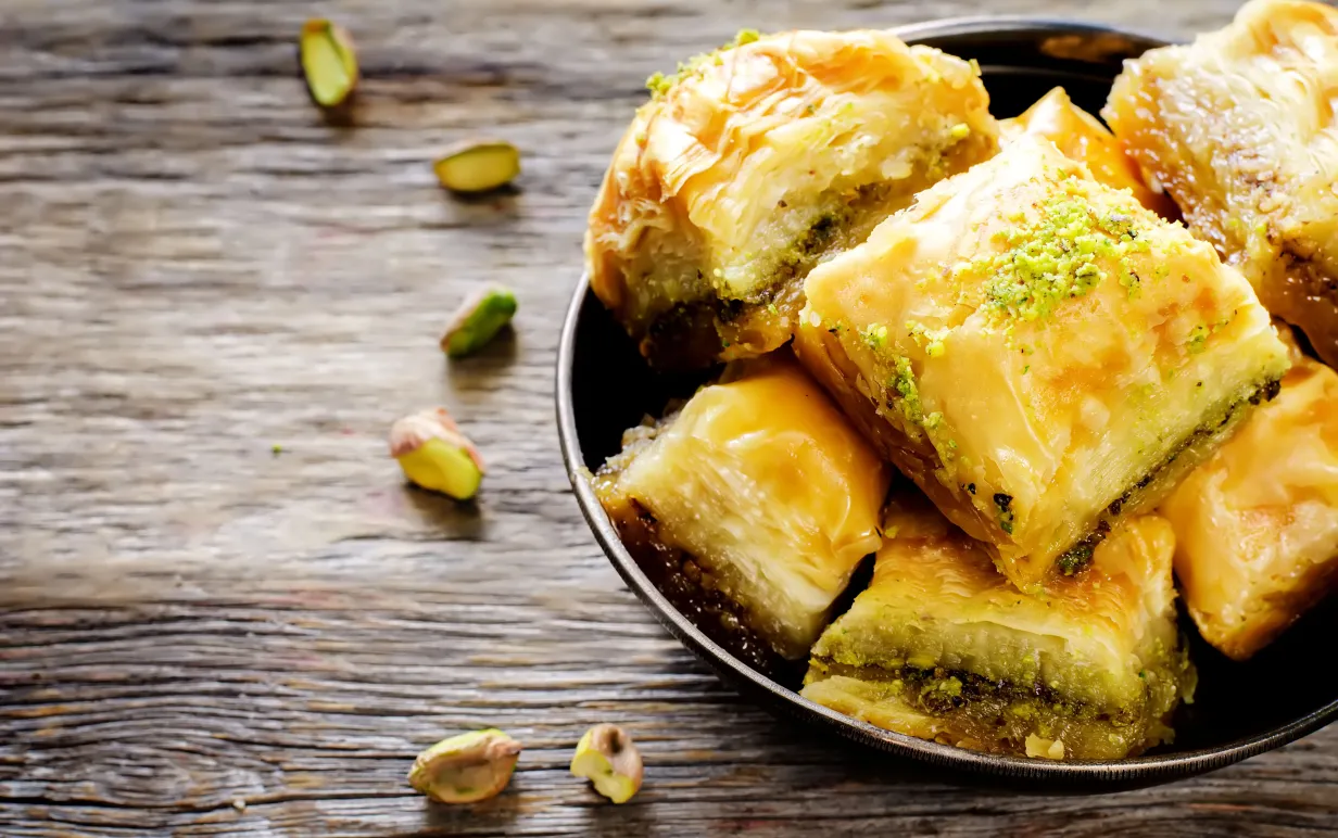Et fat med baklava på ett träbord.