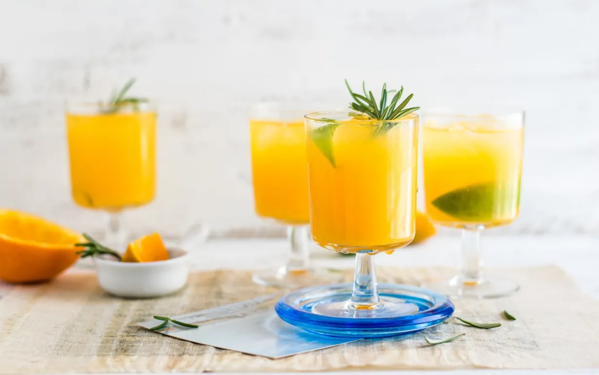 Fyra glas med juice på ett vitt bord