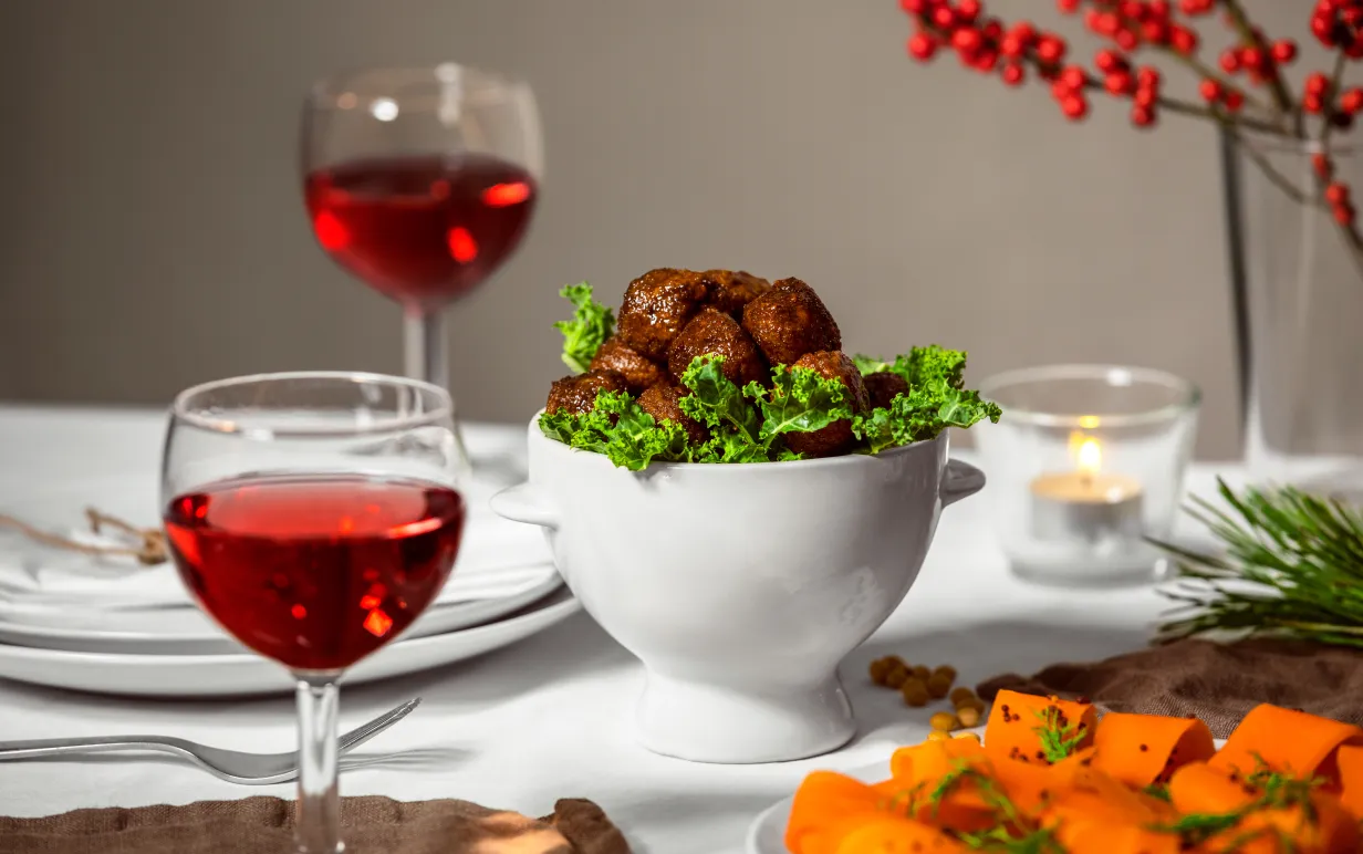 Veganska köttbullar i en vit skål på ett dukat bord