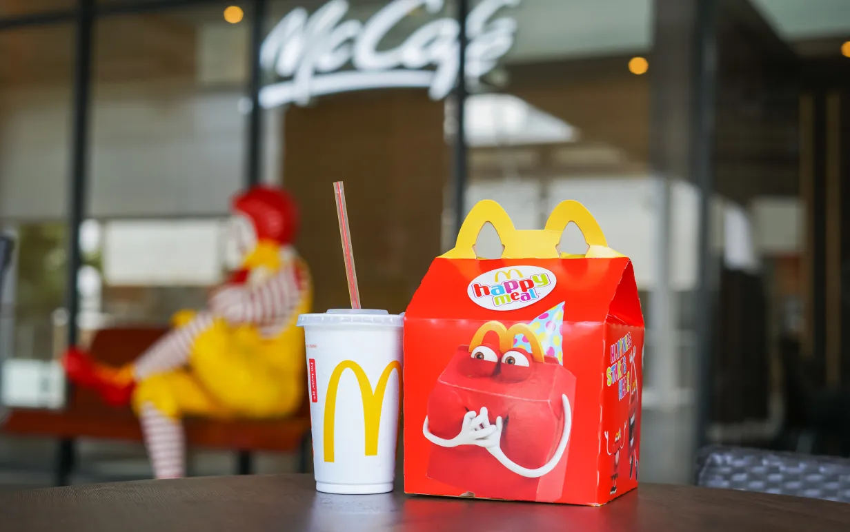 Bild på "Happy Meal" låda på ett bord med en mugg bredvid