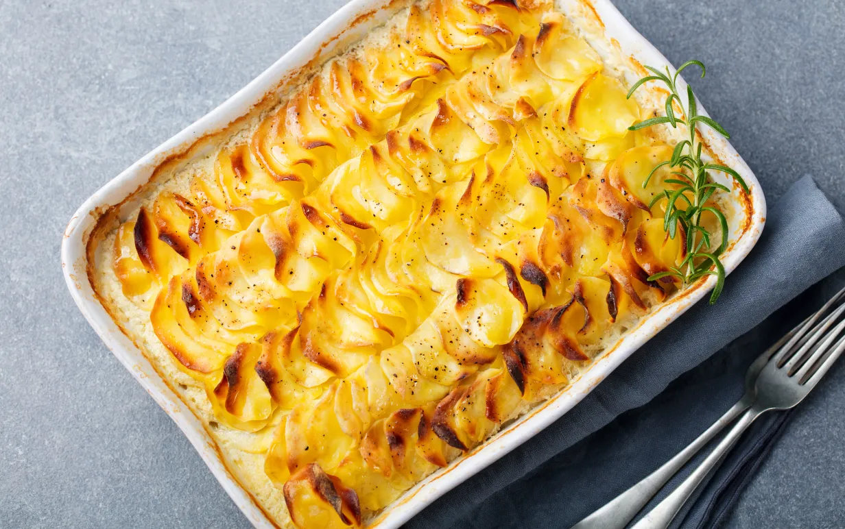 Potatisgratäng i en ugnsform på ett grått bord