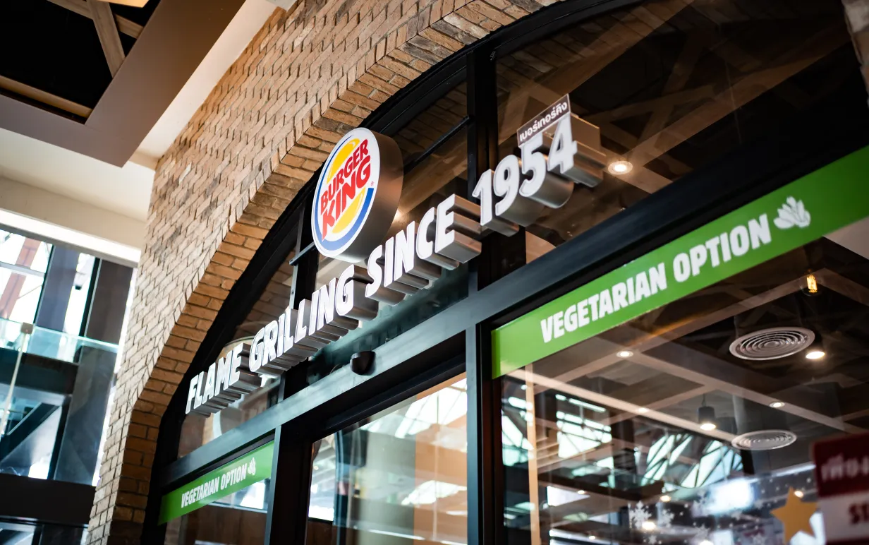 The label in front of the Burger King, hamburger fast food restaurant, showing that they have vegetarian option.